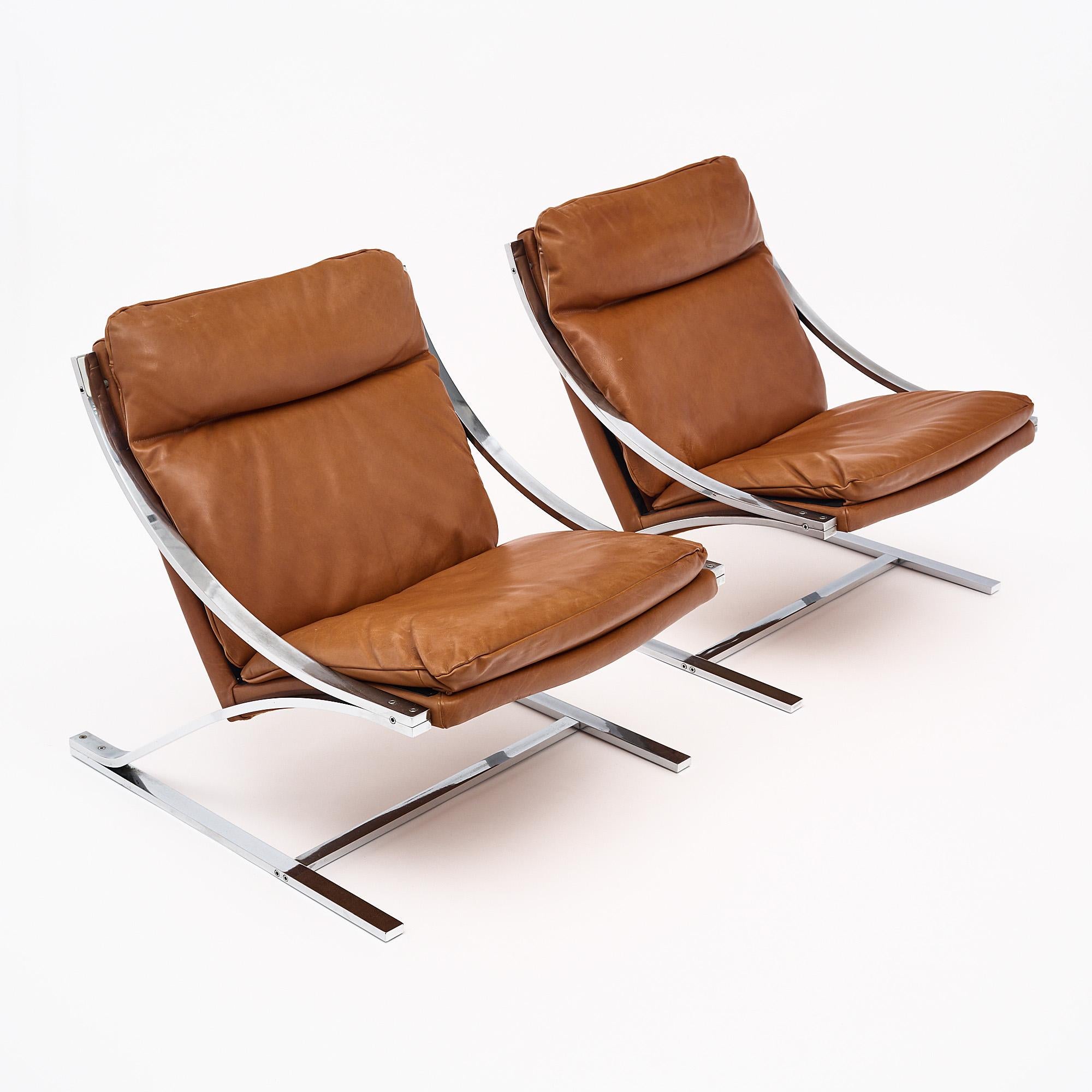 Pair of lounge chairs by American designer Paul Tuttle for Swiss brand Strässle Interntational in the 1970s. These chairs feature the soft cognac colored leather upholstery original to the pair. The “Zeta” style chairs get their name and design from