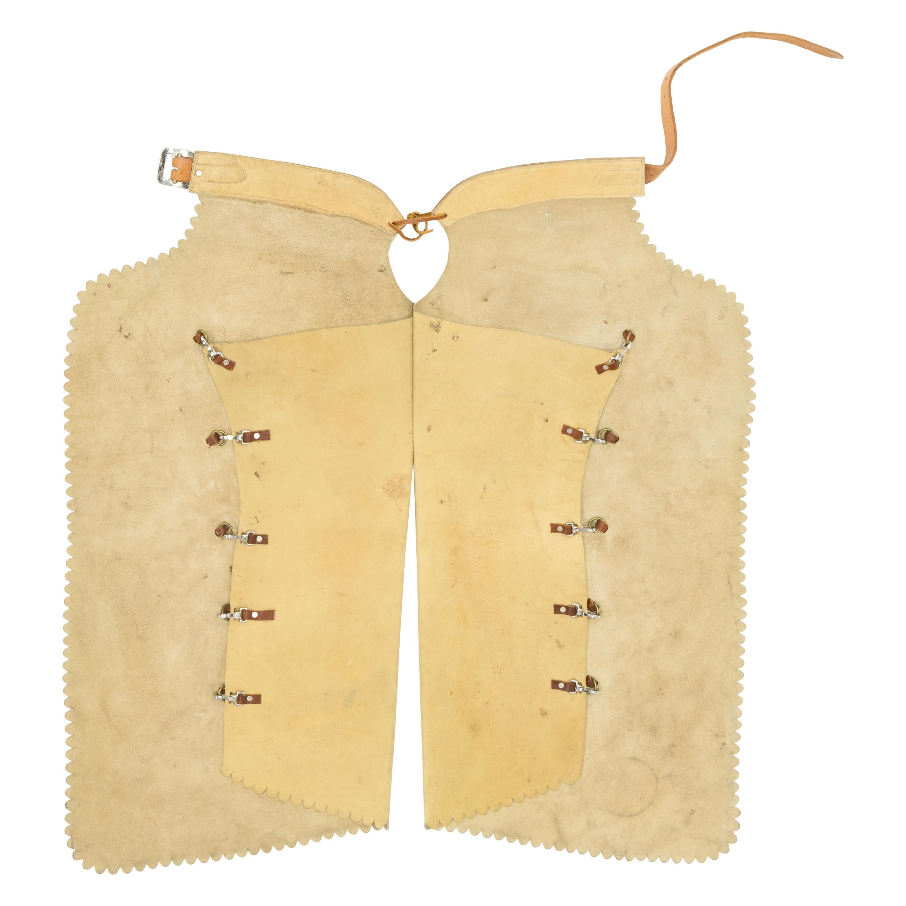 Vintage batwing chaps with outside pockets, leather conchos and basketweave belt. Leather is a light, beige color with warm, natural brown pockets, decorative card suits, and concohs. Unmarked, with C11 on lower left corner. Would display nicely in