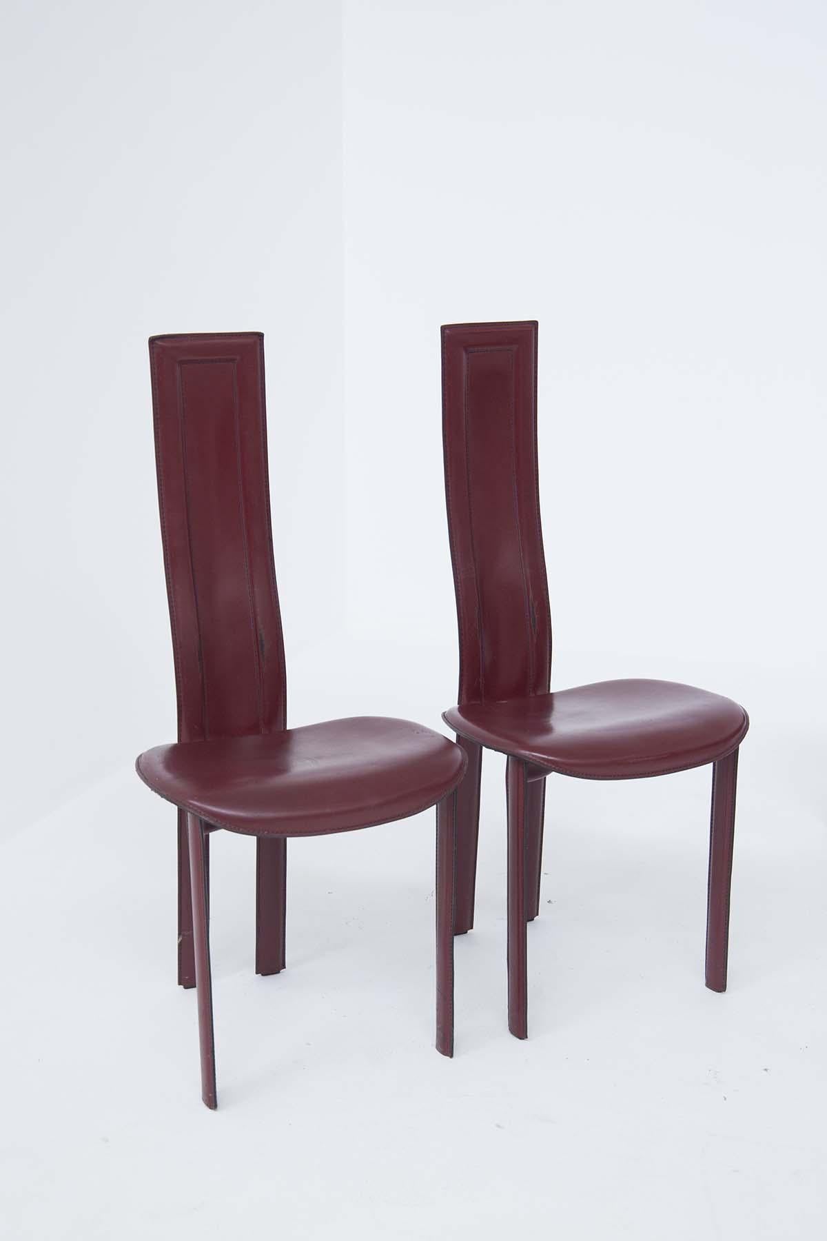 Lot de 6 chaises de table en cuir bordeaux avec surpiqûres apparentes, quatre sont pour le côté de la table, deux sont les chaises de tête, avec un dossier plus haut et plus long, leur assise est arrondie.
Tous les fauteuils en cuir vintage ont