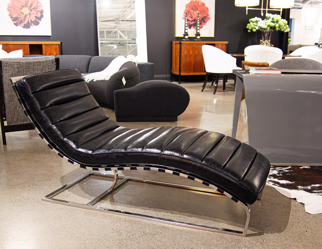 This vintage leather chaise lounge chair is a timeless piece of French craftsmanship from the 1970s. Featuring a channeled design in black leather with a beautiful, aged patina. Accented with a stainless steel support frame to provide strength and