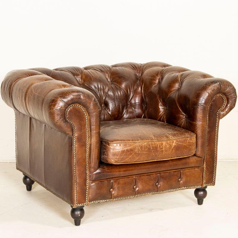 Original vintage leather Chesterfield club chairs are highly sought after today. The rich, dark brown leather here is accented with the traditional tufted Chesterfield back, heavily rolled arms and nailhead accents. The leather is in vintage