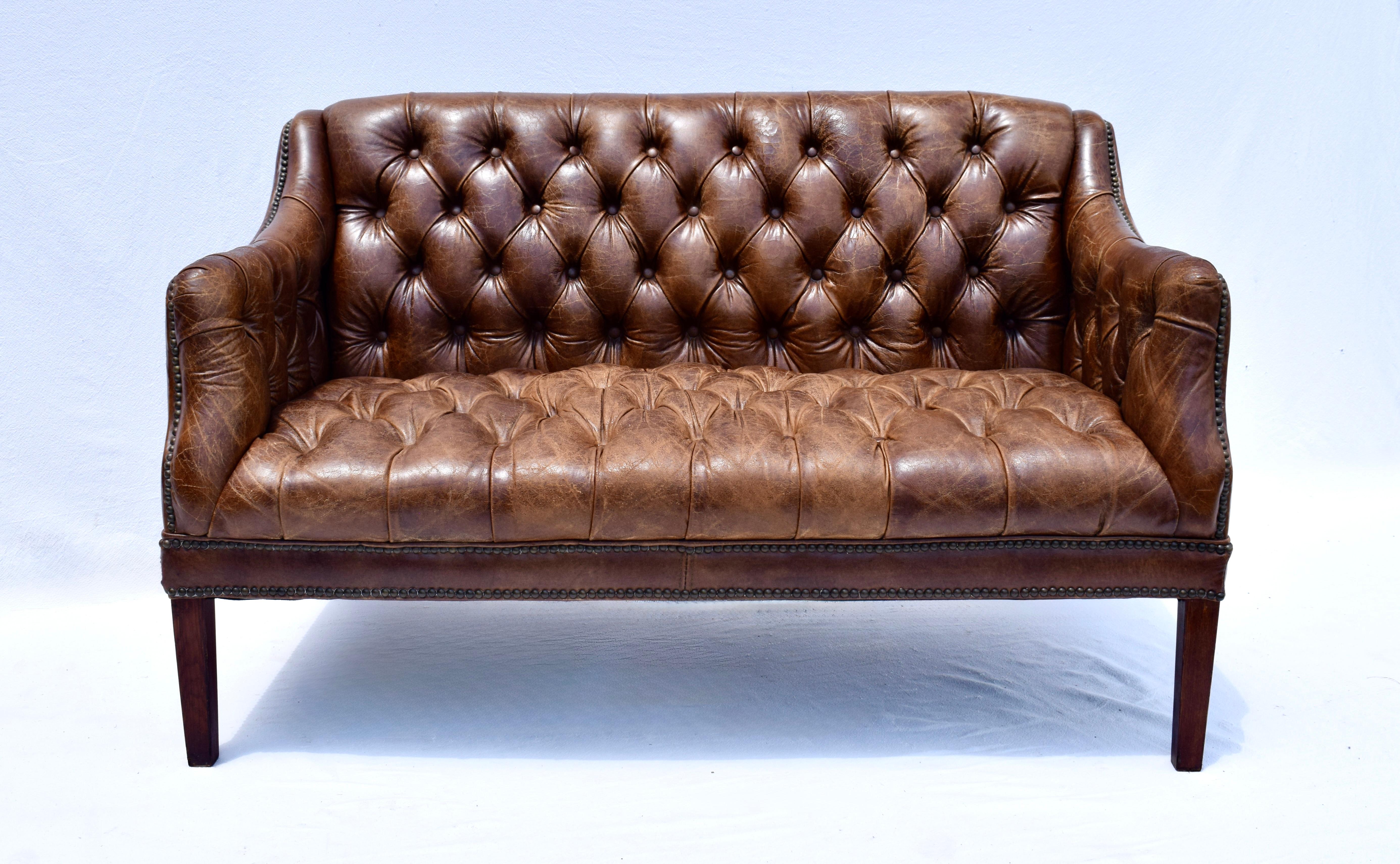 Loveseat Chesterfield de cuero vintage marrón castaño con respaldo de mechón tradicional y detalles de tachuelas.  El cuero está perfectamente patinado, en un estado clásico vintage ligeramente desgastado, sin desgarros ni daños; en estado original