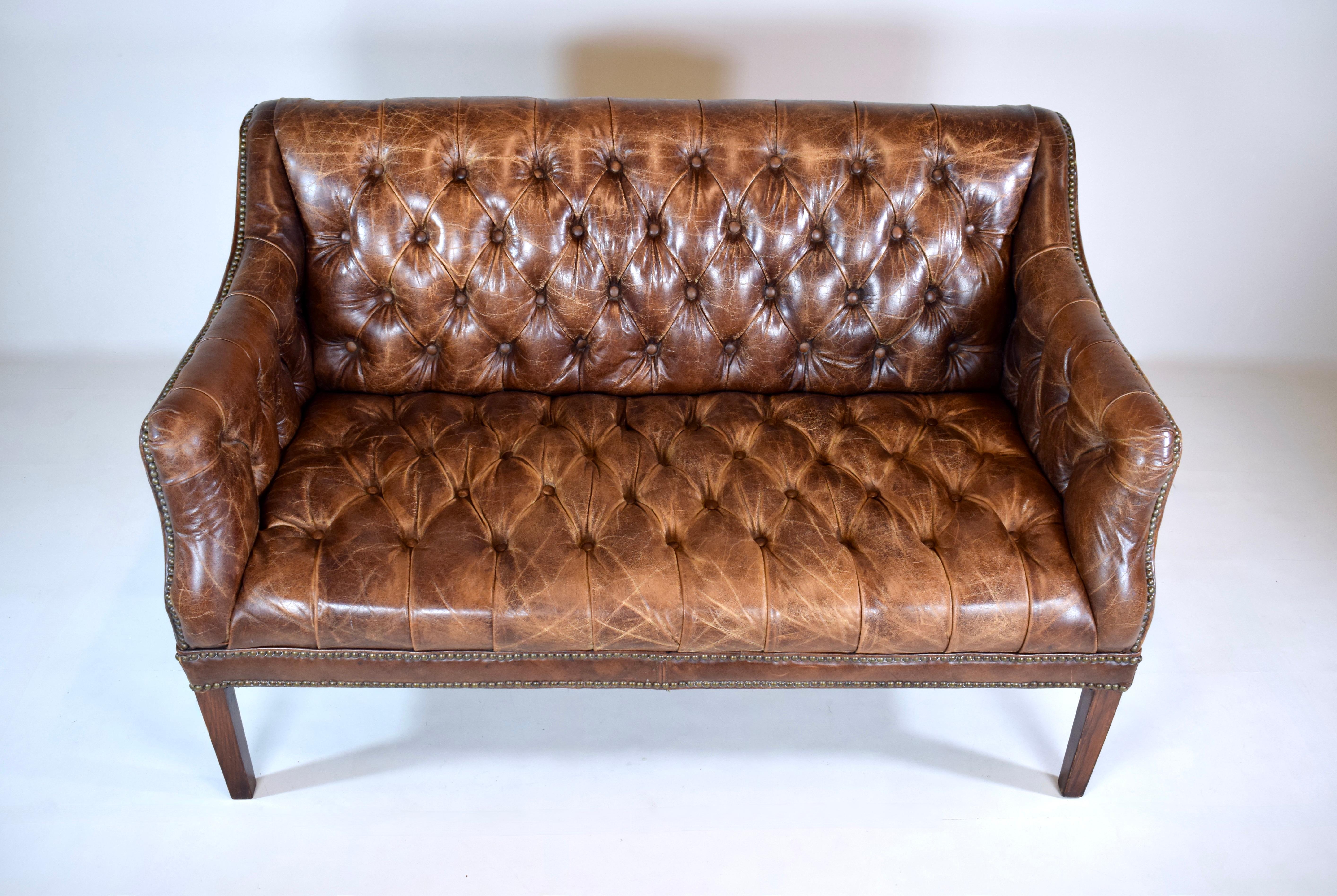 Loveseat Chesterfield de cuero vintage marrón castaño con respaldo de mechón tradicional y detalles de tachuelas.  El cuero está perfectamente patinado, en un estado clásico y vintage, sin desgarros ni daños.  Silueta muy cómoda, de 53