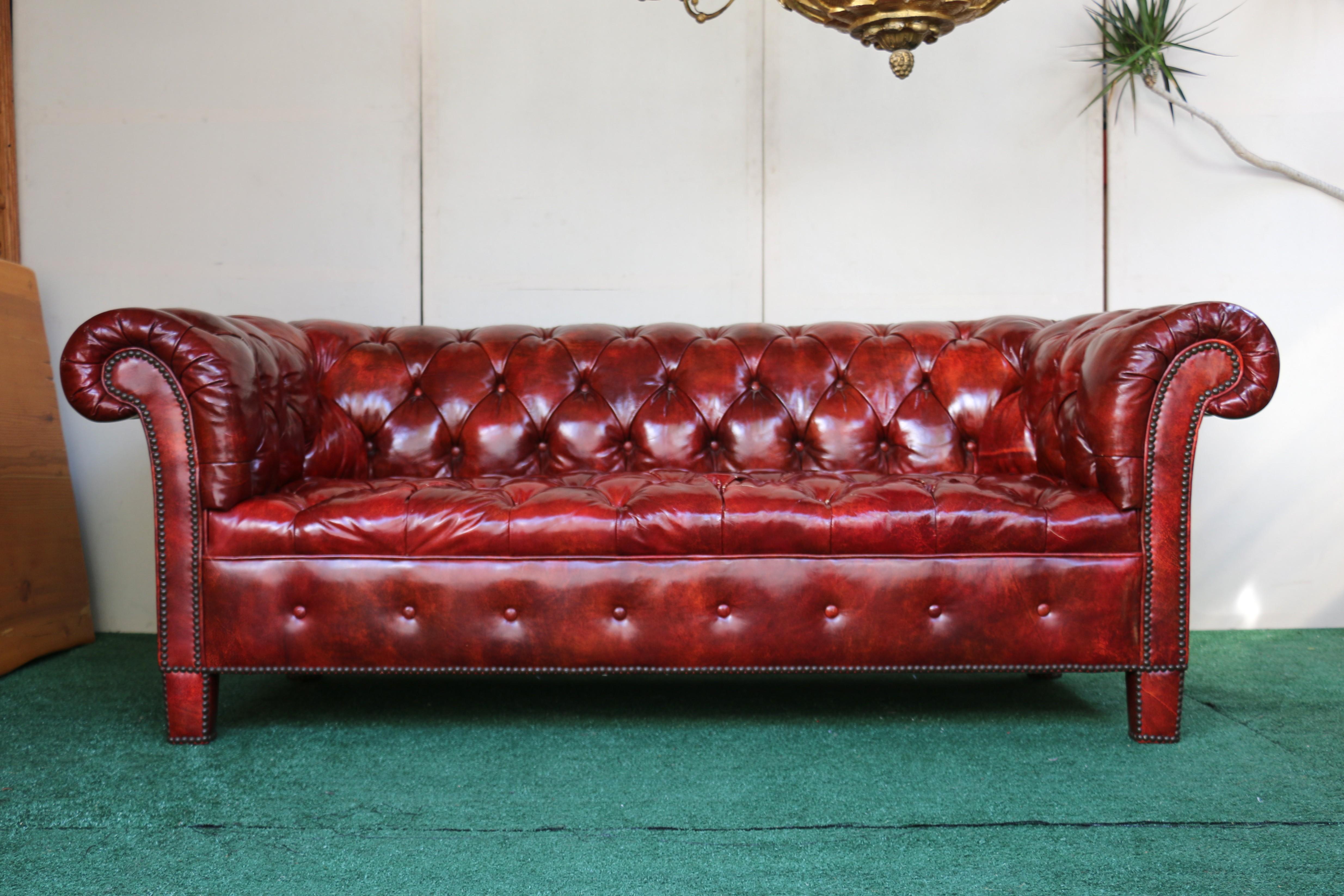 Spectacular chesterfield sofa designed by Baker Furniture, Circa 1950’s. This sofa is made of original leather with a tufted back and seat, ( the bottoms are well attached to the sofa). It has scrolled arms with the same high as the back. Cap brass