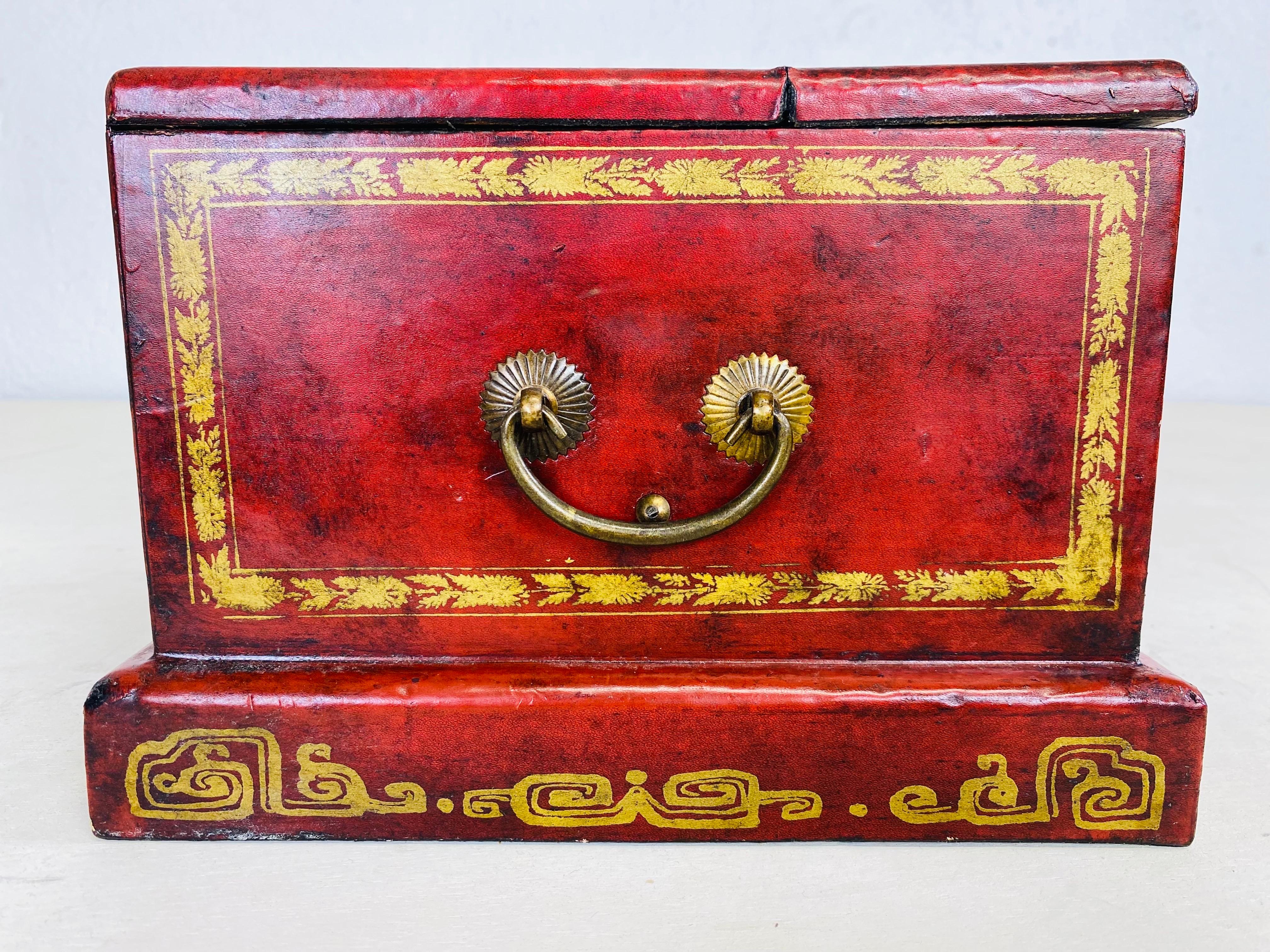 This is a vintage hand painted leather clad dresser box. This dresser box was handmade in Canton China. This box has two small drawers at the front and a lid that opens up and presents a dressing mirror. This box was made in China circa 1990.