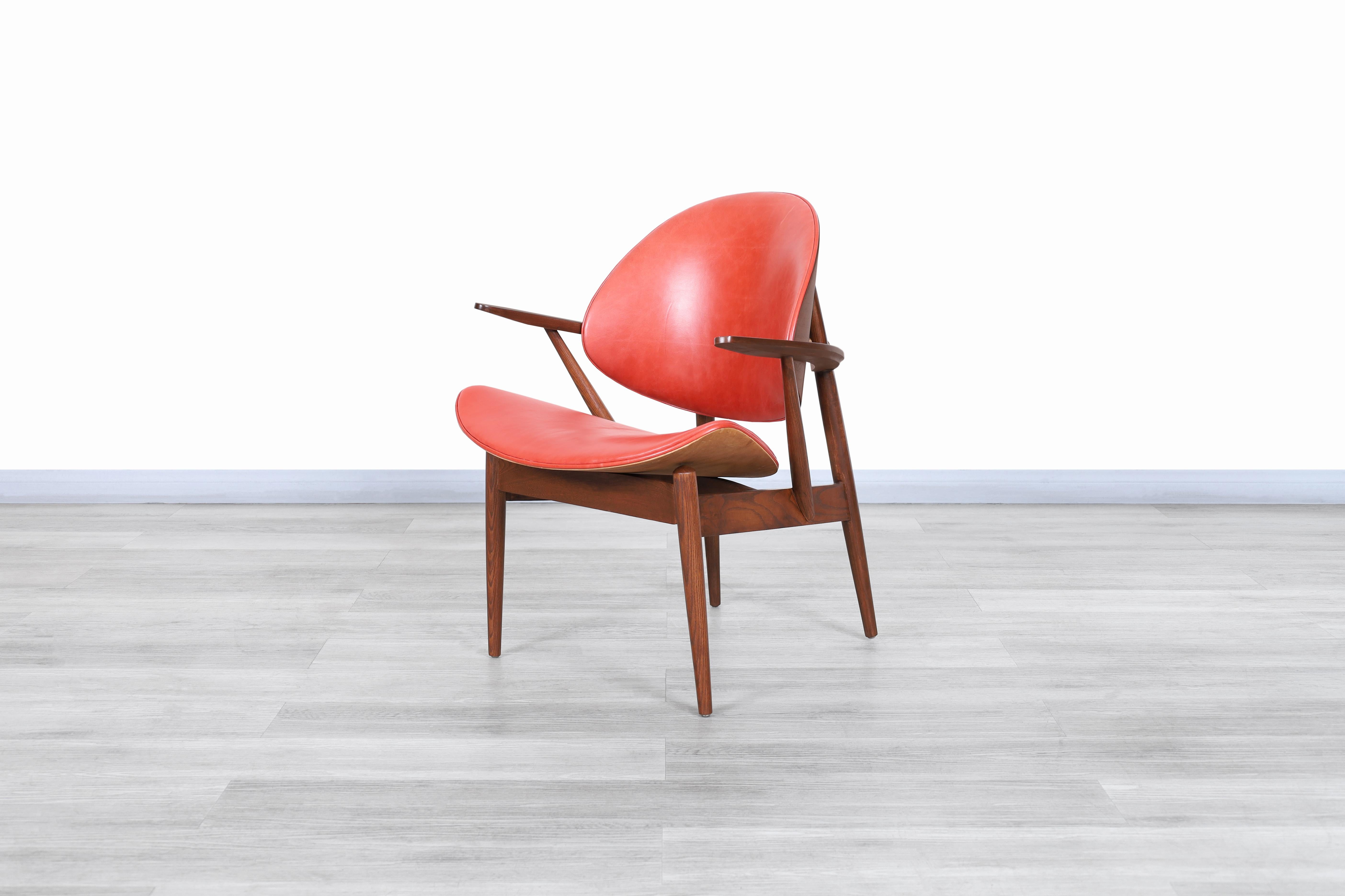 Fabulous vintage leather “Clam Shell” armchair designed by Seymour J. Wiener for Kodawood in the United States, circa 1960s. The chair's structure has been carefully constructed from the highest quality walnut wood, making it even more special as it