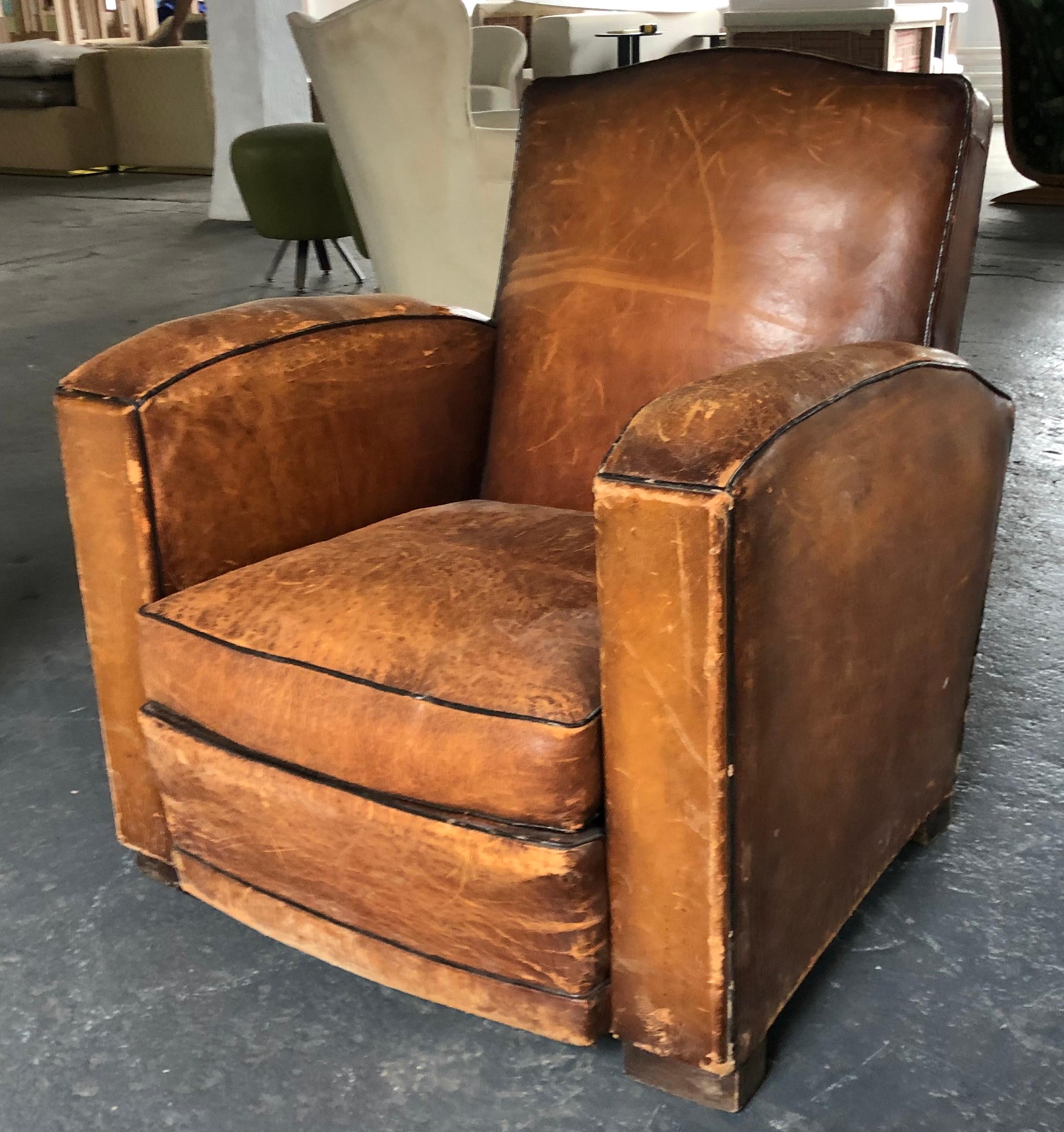 Vintage leather club chair in original saddle leather with contrast welting. Measures: The arm height is 24