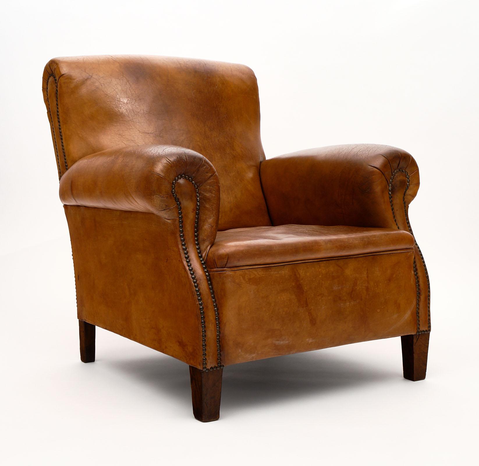 Vintage leather club chair with ottoman. This piece is all original with a beautiful patina to the leather upholstery and brass studs. It is very comfortable. We love the tapered legs and large scale of the ottoman.
The dimensions listed are for