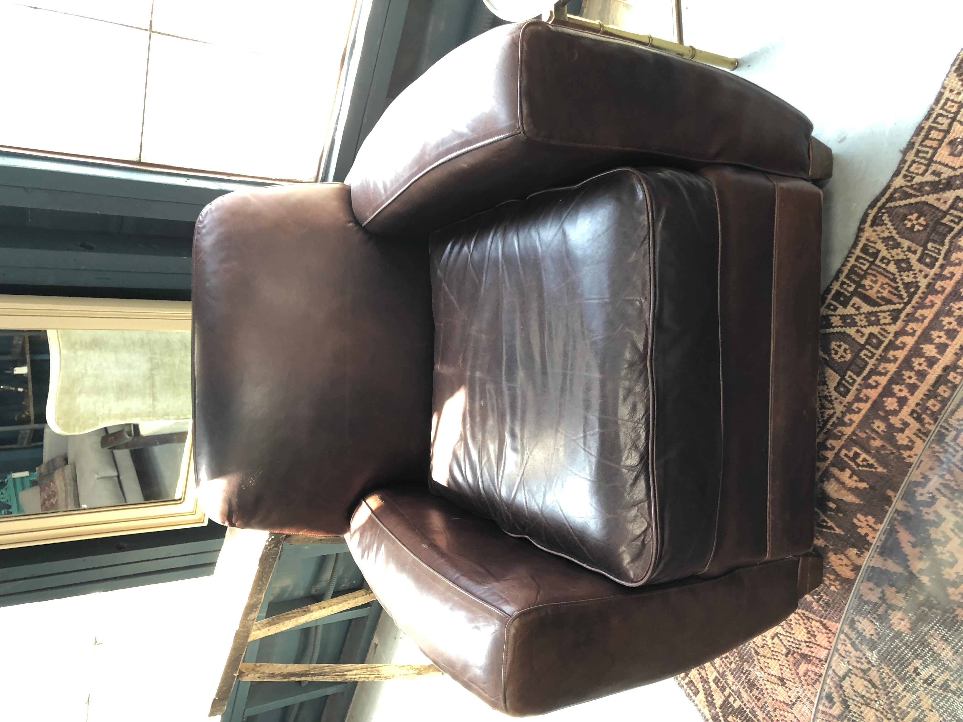 A pair of dark slightly worn vintage leather club chairs. Measurements: 33