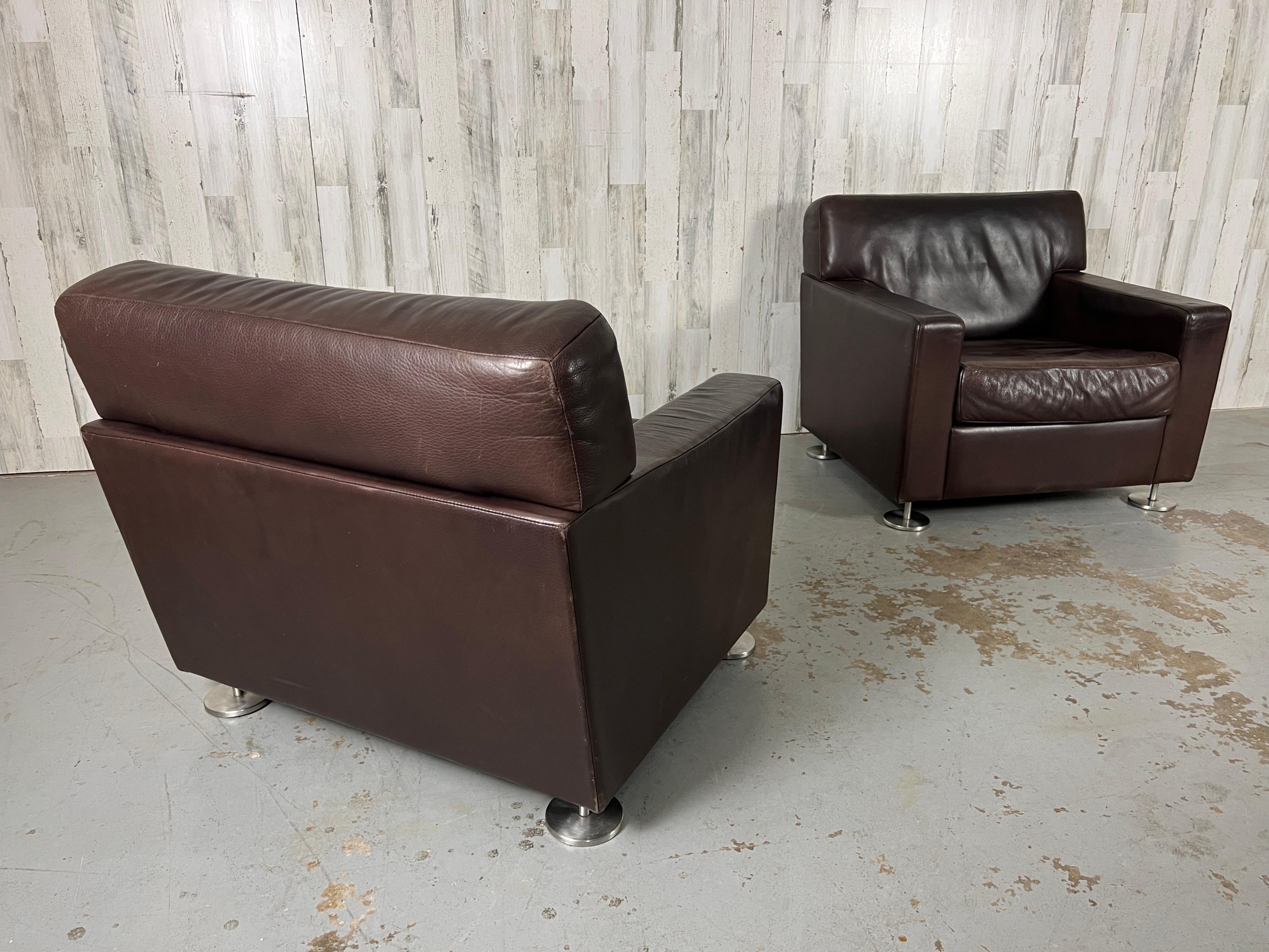 Nice wear and patina on the leather of these Vintage modern lounge chairs with sturdy stainless steel pod legs.