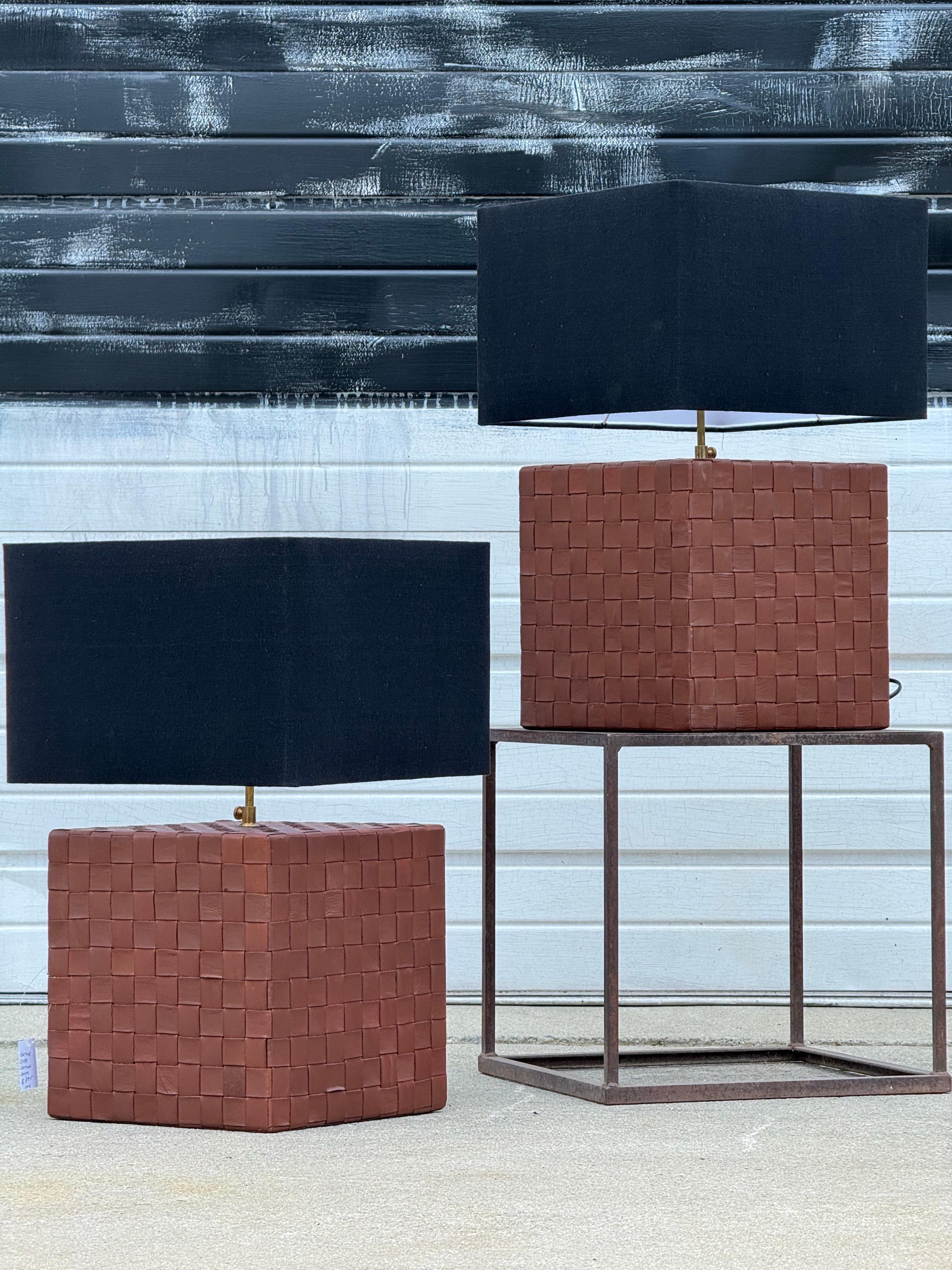 Really interesting vintage table lamps. Cube in shape with leather cross-hatch exterior. Brass hardware equipped with black shades. Chunky and modern in style. Would work well with many style interiors; for mid-century to farmhouse and rustic