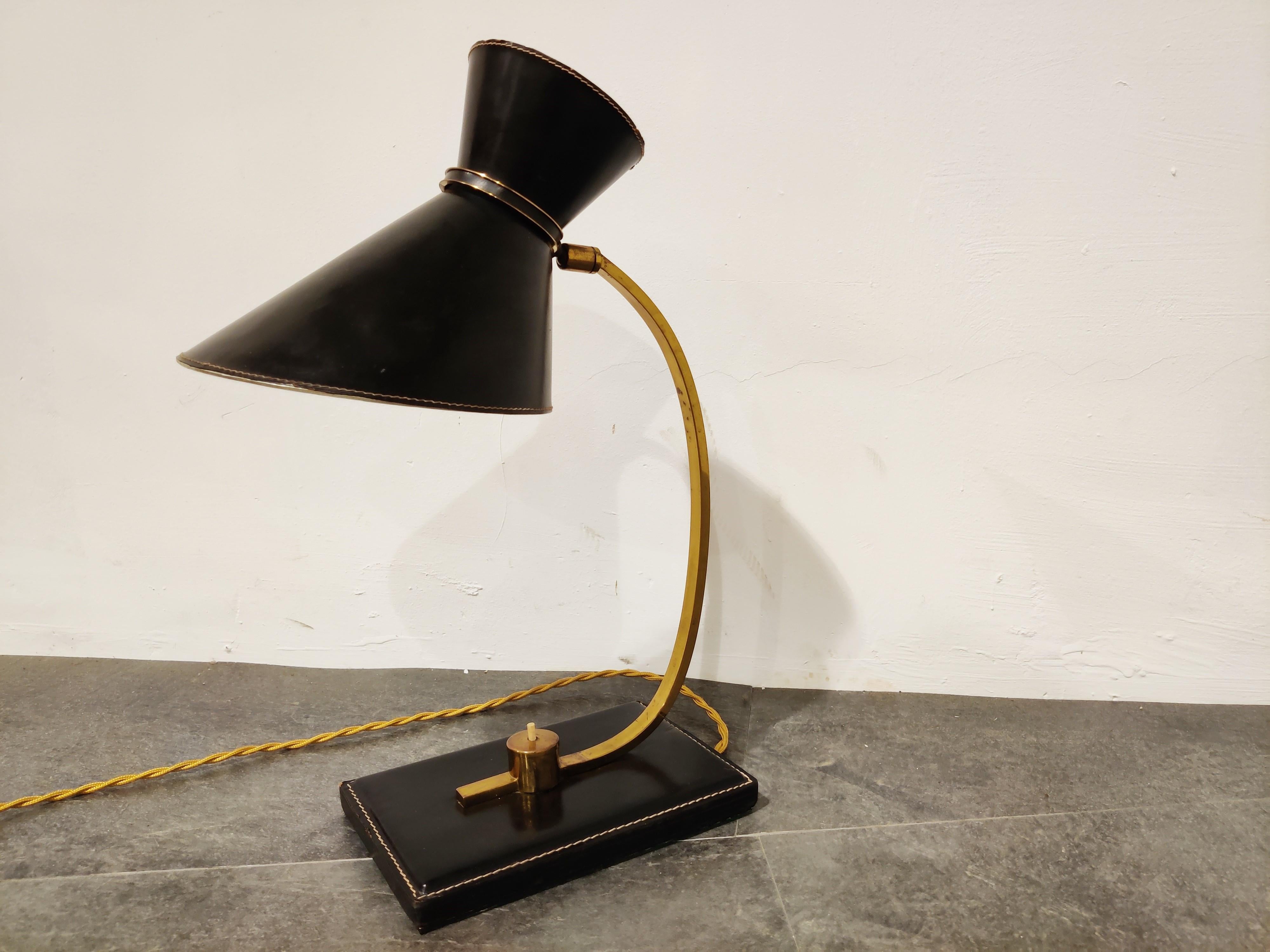 Midcentury diabolo shade desk lamp made from brass and leather, designed by Frenchman Jacques Adnet (1901-1984). Jacques Adnet was a representative of French Modernism.

The lamp is in good original condition with new braided wire.

The lamp