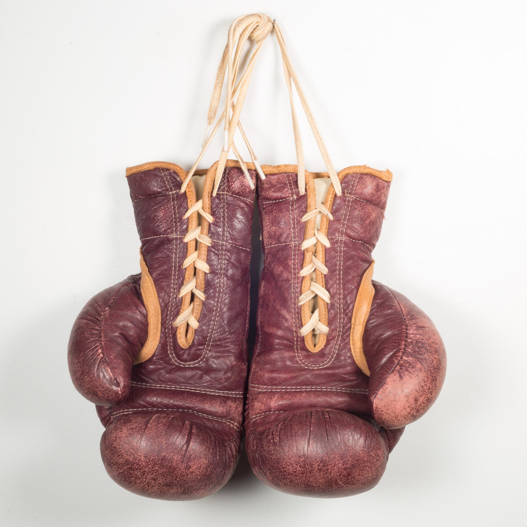 À propos de

Il s'agit d'une paire originale de gants de boxe en cuir Everlast. Les gants de boxe sont en cuir marron avec un passepoil en cuir doré, des lacets crème et une grande étiquette 