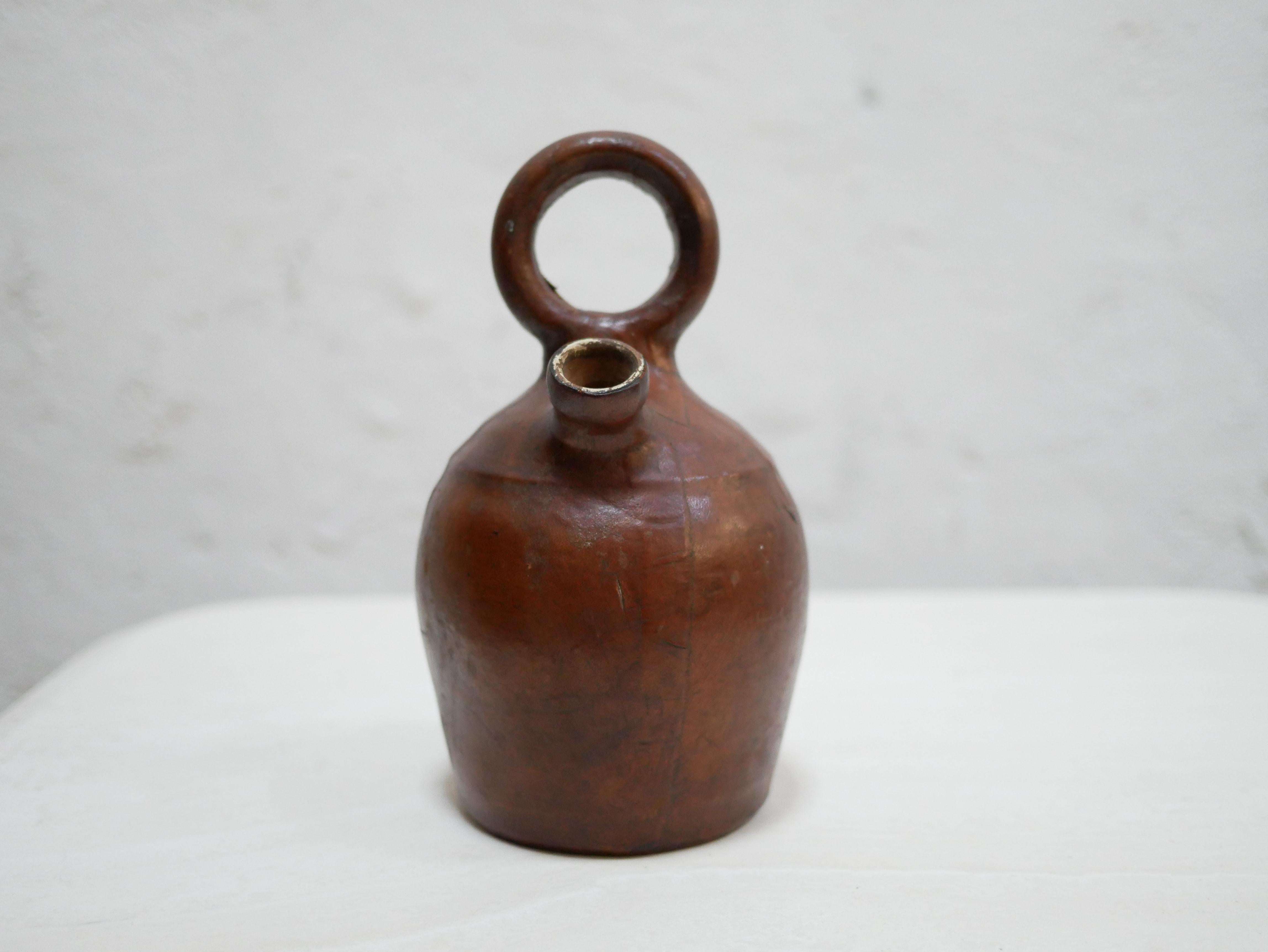 Terracotta pot covered in leather dating from the 1950s.

With its modern shape and the pretty patina of the leather, this object will be perfect in a natural, refined and delicate decoration.
We simply imagine it placed on a shelf or a piece of