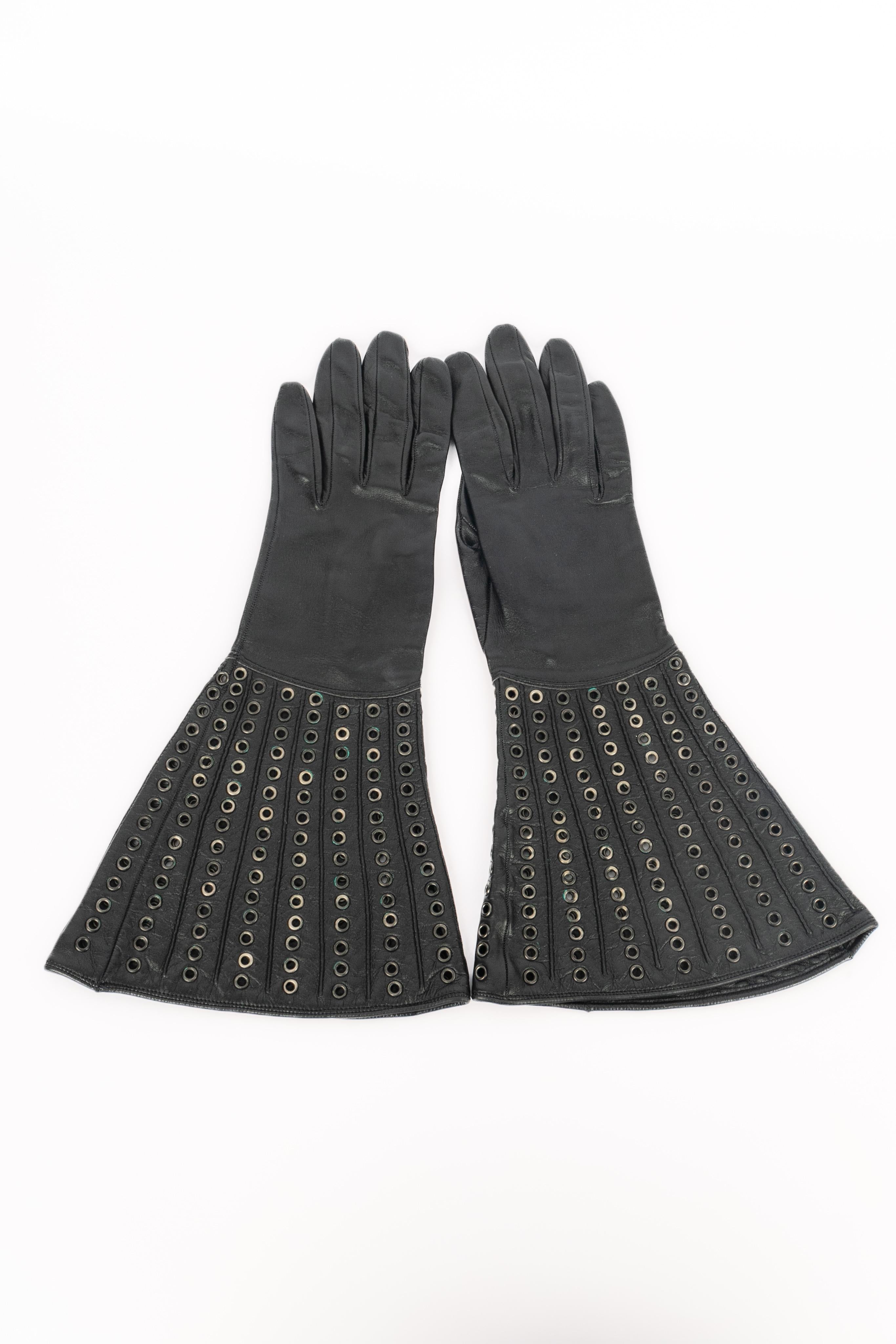 UNKNOWN - Black leather gloves decorated with eyelets.

Condition:
Good condition

Dimensions:
Length: 33 cm

SKU:ACC44