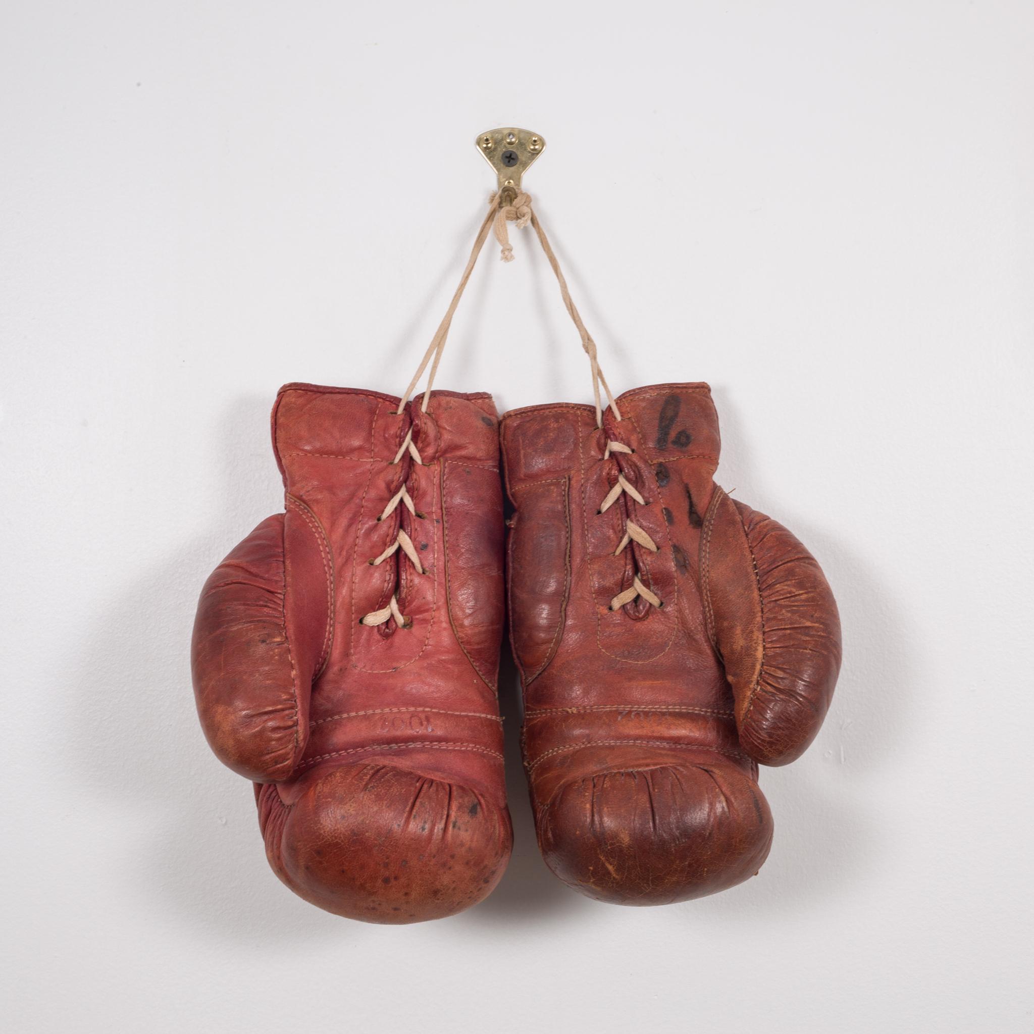 About

This is a original pair of vintage boxing gloves. The gloves are a maroon leather with white laces. They are both have a label 