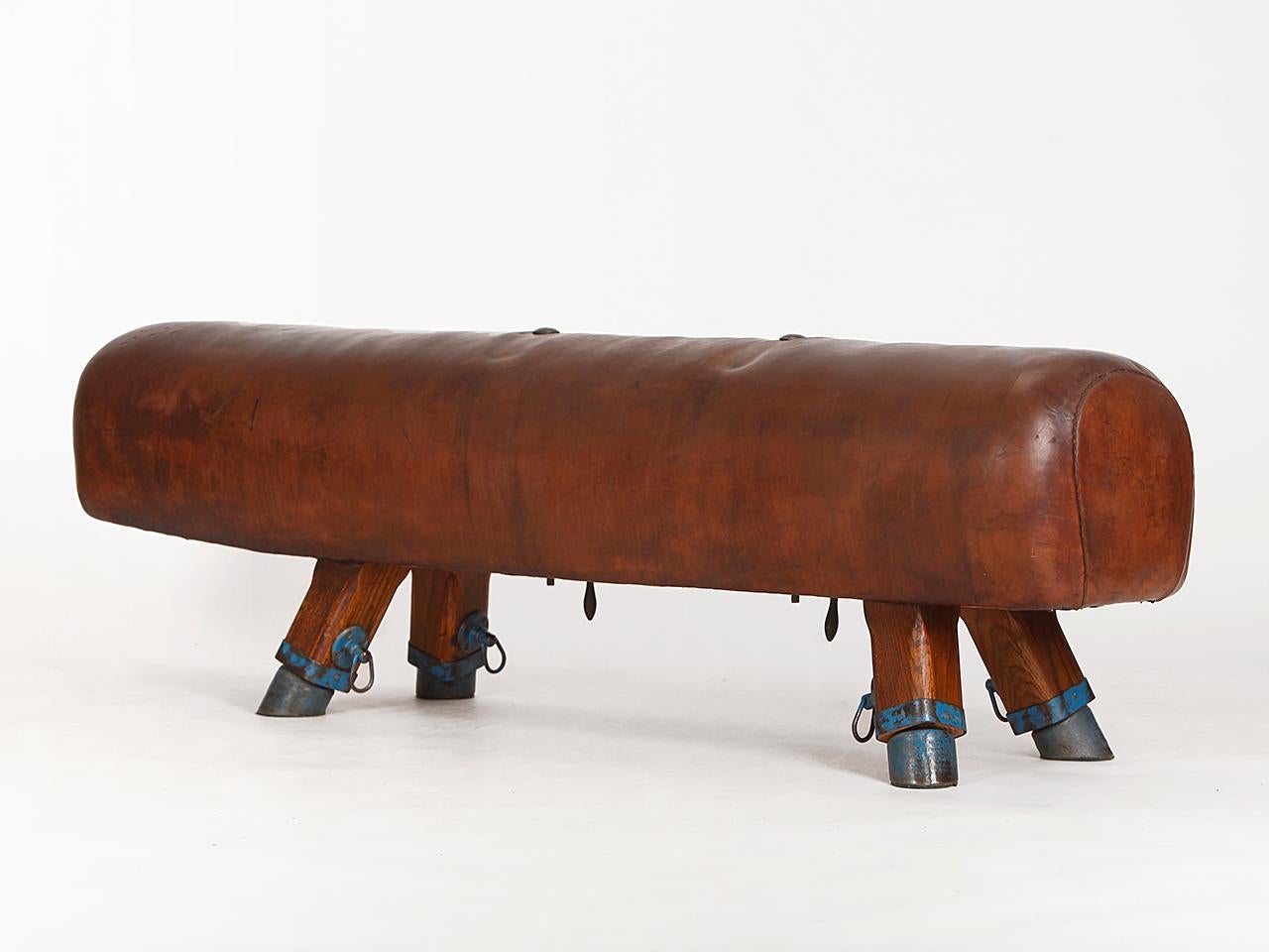 Produced in the early 20th century, former Czechoslovakia. The legs of this pommel horse were shortened to a seat height of 56cm. The thick patinated cowhide leather has been cleaned and preserved.