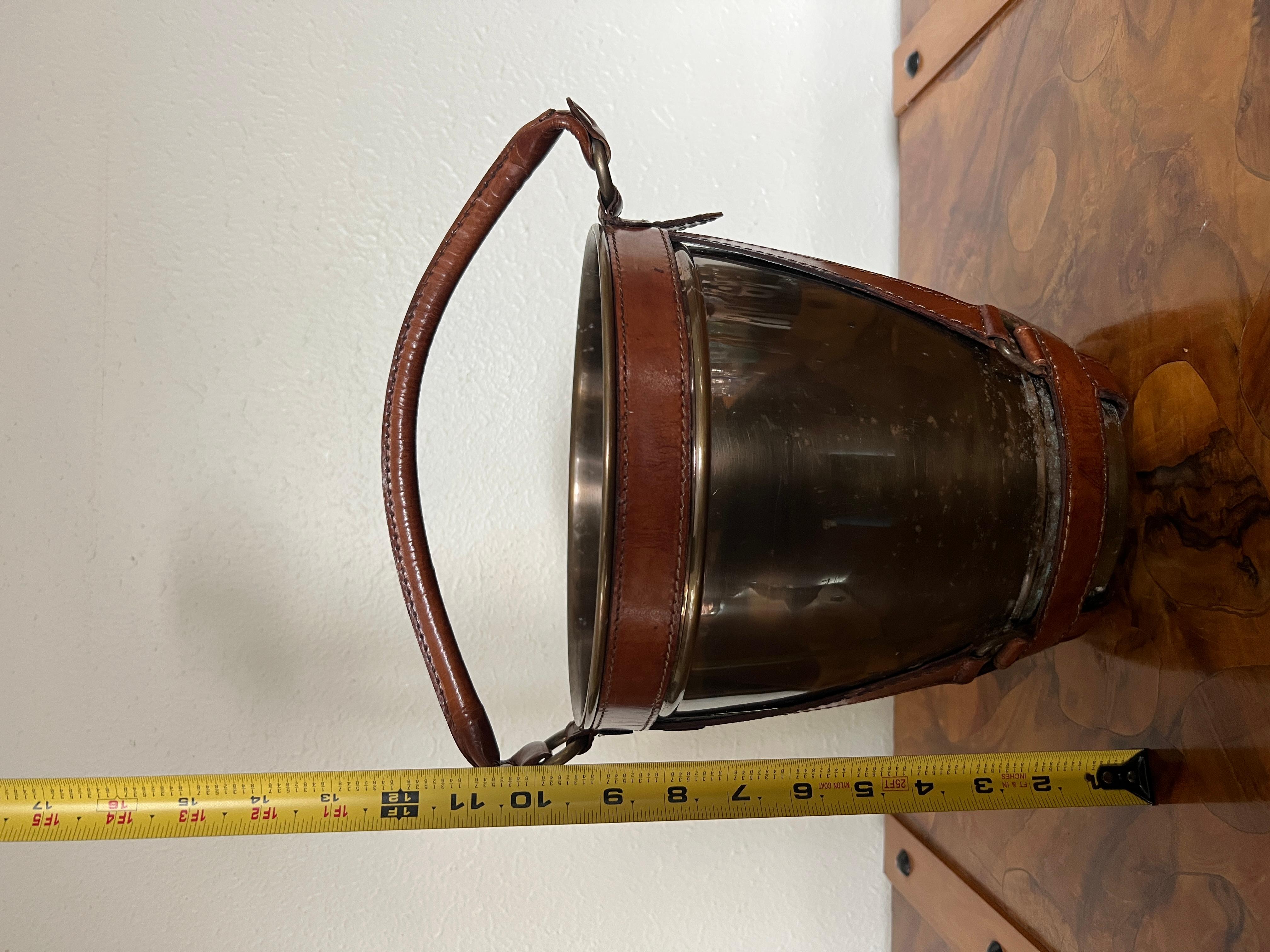 Leather handle midcentury style champagne ice bucket.

Handsome midcentury style modern ice bucket decorated with leather stripes and leather handle. An eye catching piece.