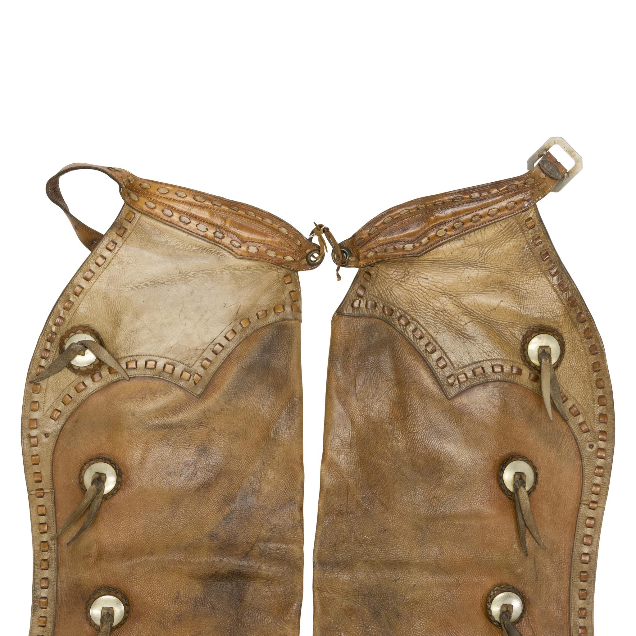 Vintage leather Heiser batwing chaps with buck stitched edging and conchos. Nice patina to leather and nice light coloring. In good condition for use or display in a Western or Southwestern style home. Size: 38