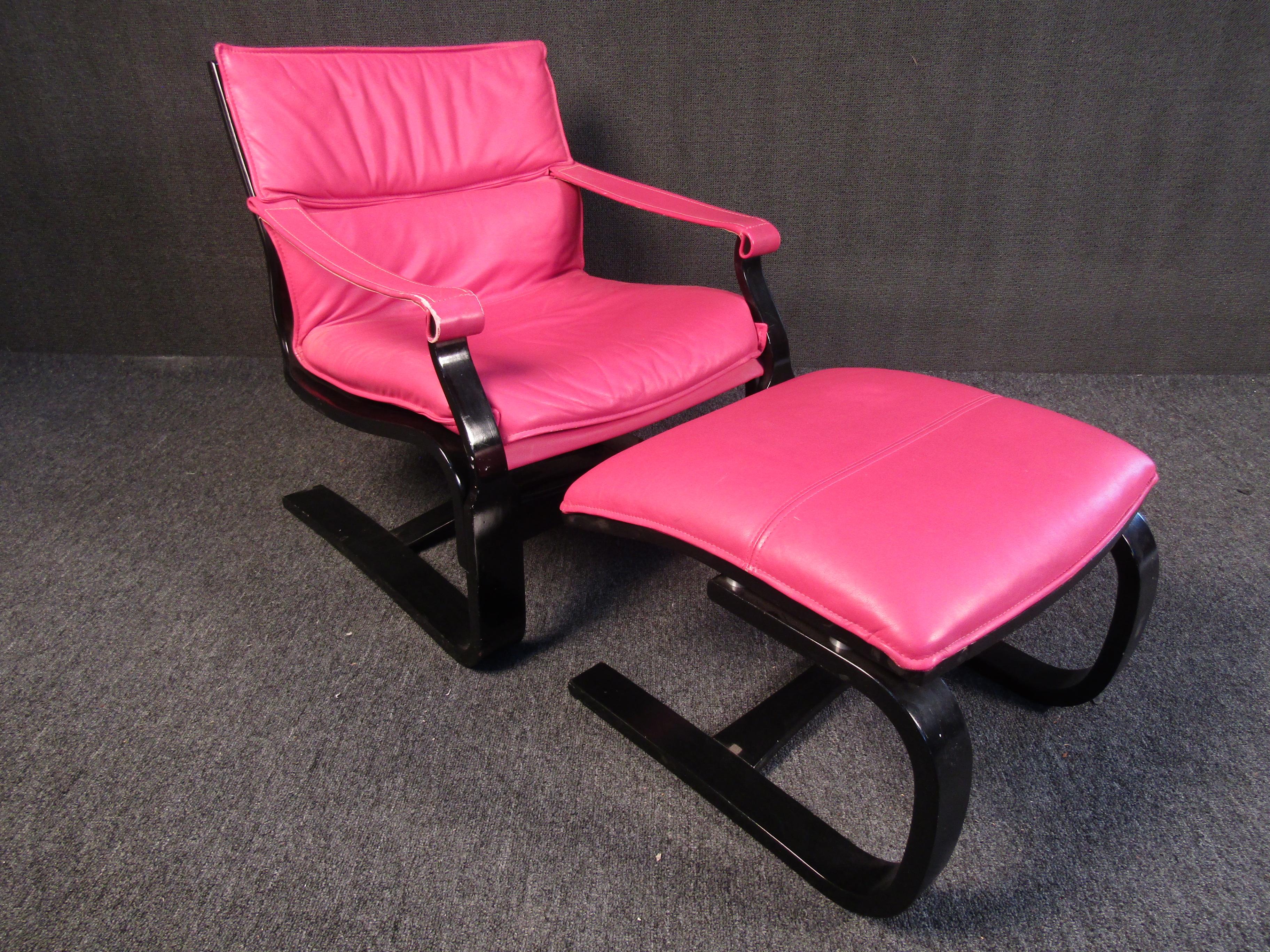 This vintage lounge chair and ottoman set is full of bold Mid-Century Modern style. Vibrant pink leather contrasts with a black wooden frame making this set as eye-catching as it is comfortable. Please confirm item location with seller (NY/NJ).