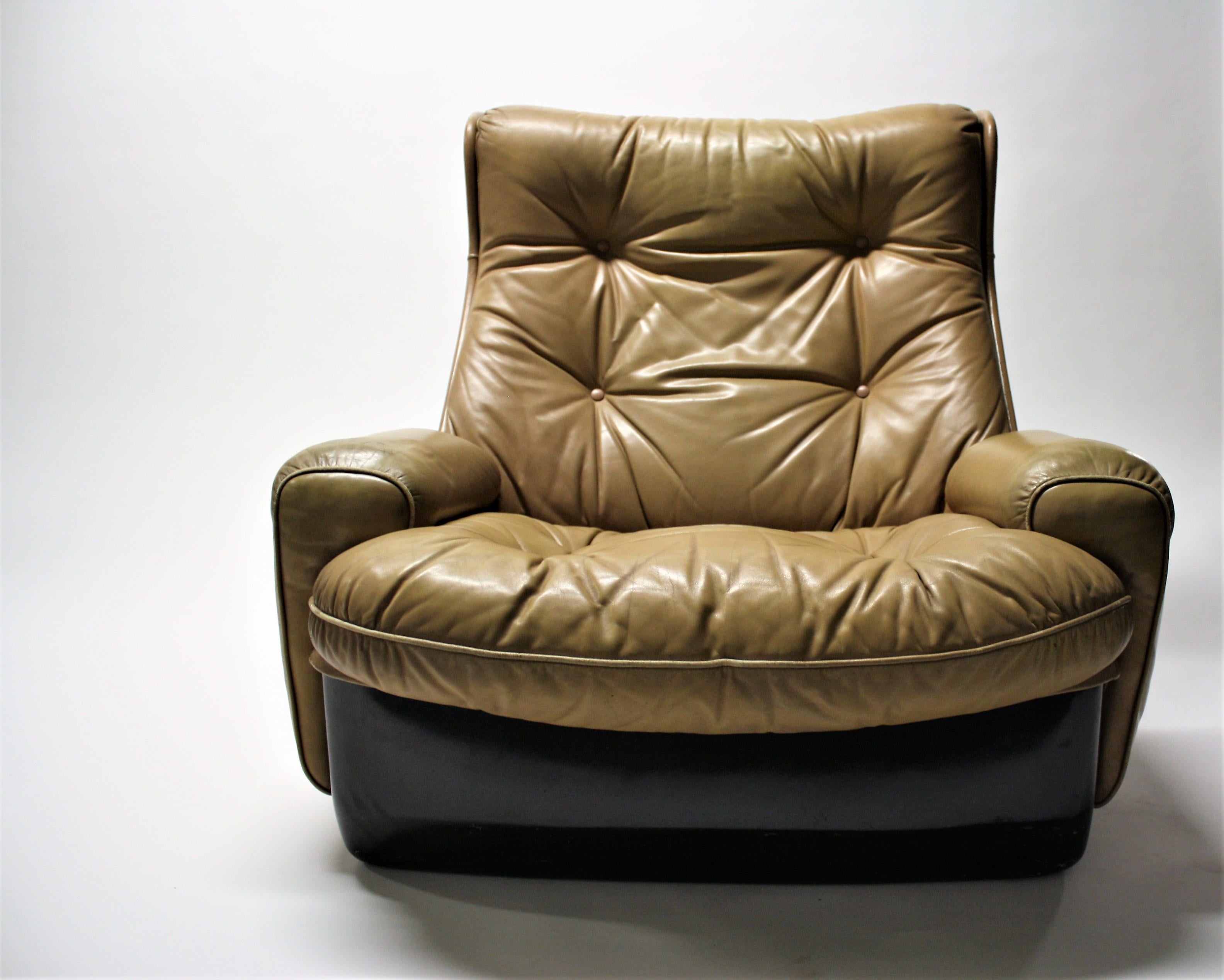 Striking space age lounge chair by Airborne international.

The chair consists of a black fiberglass shell upholstered with beige butonned leather.

It sits as comfortable as it looks, which is a good thing.

The black and brown colours give