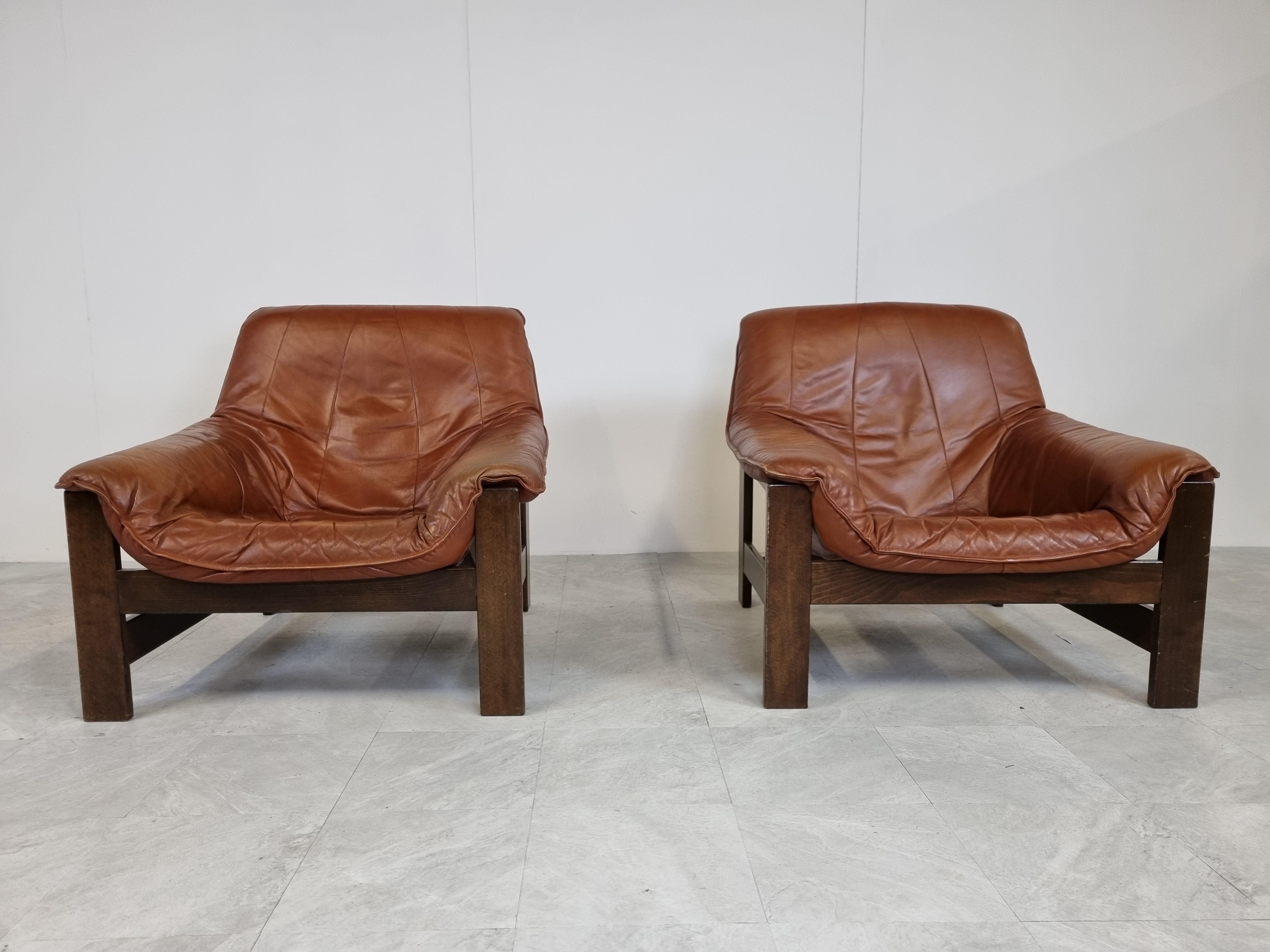 Pair of brown leather lounge chairs with solid oak frames.

Good condition with normal wear.

1970s - Germany

Dimensions
Height: 82cm/32.28