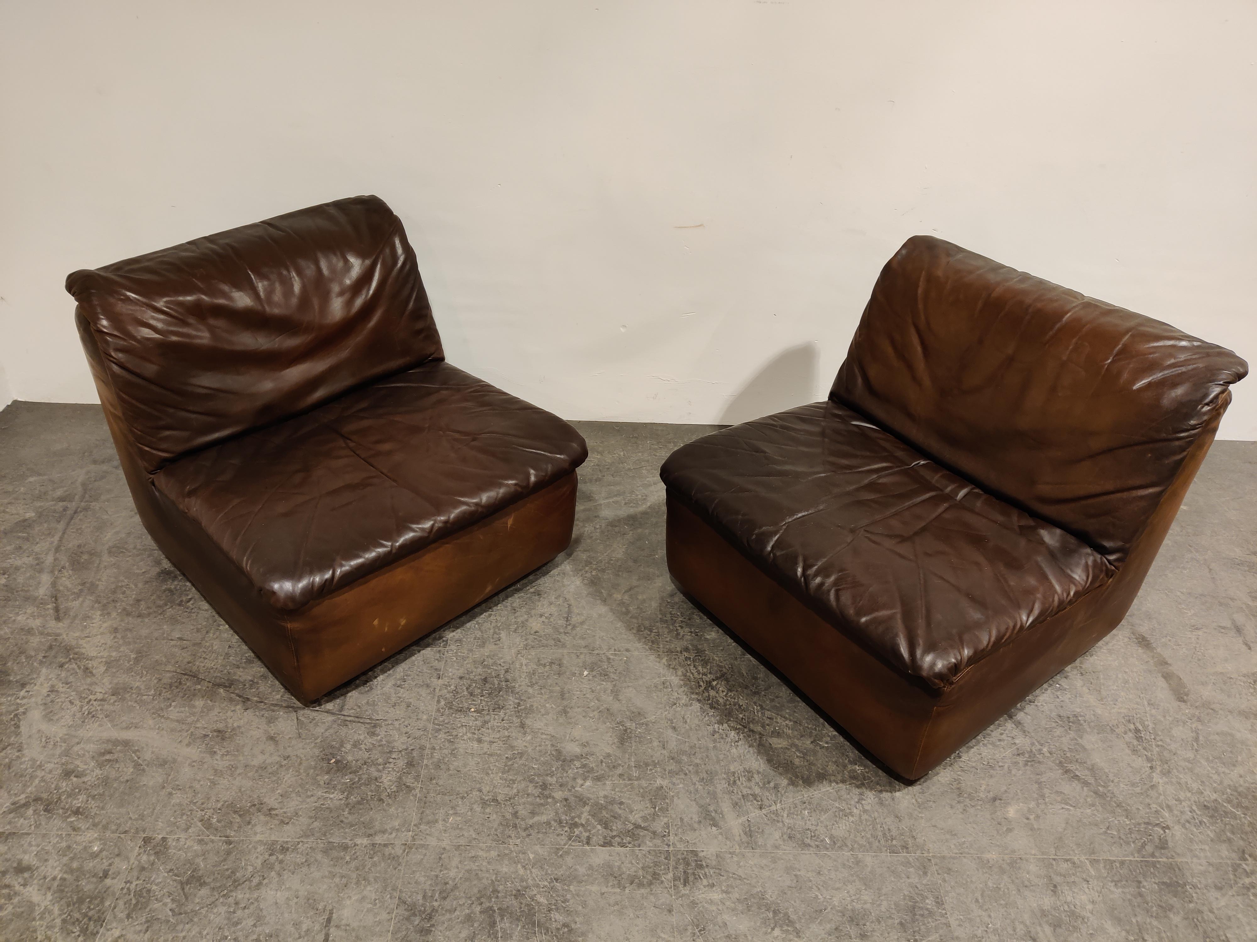 Pair of leather lounge chairs/sofas by Durlet.

Great seventies look with patinated leather.

The leather is in used condition but no rips/holes and looks great. 

1970s, Belgium

Measures: Height 72cm/28.34