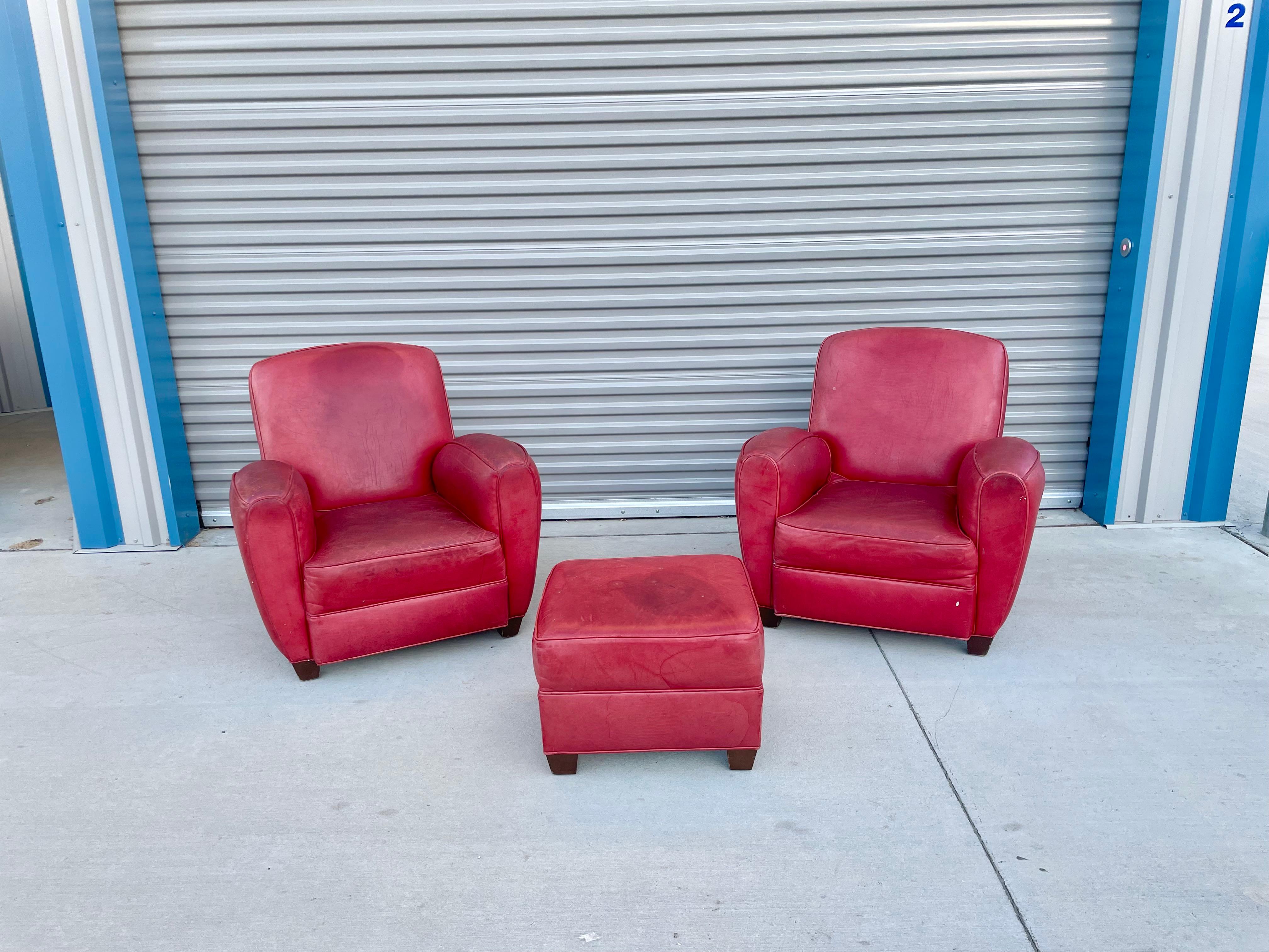 Beautiful vintage leather chairs & ottoman manufactured in the United States circa 1960s. This set retains its original red leather in nice vintage condition with only minor signs of wear, but still gives a great distinctive design for their era.