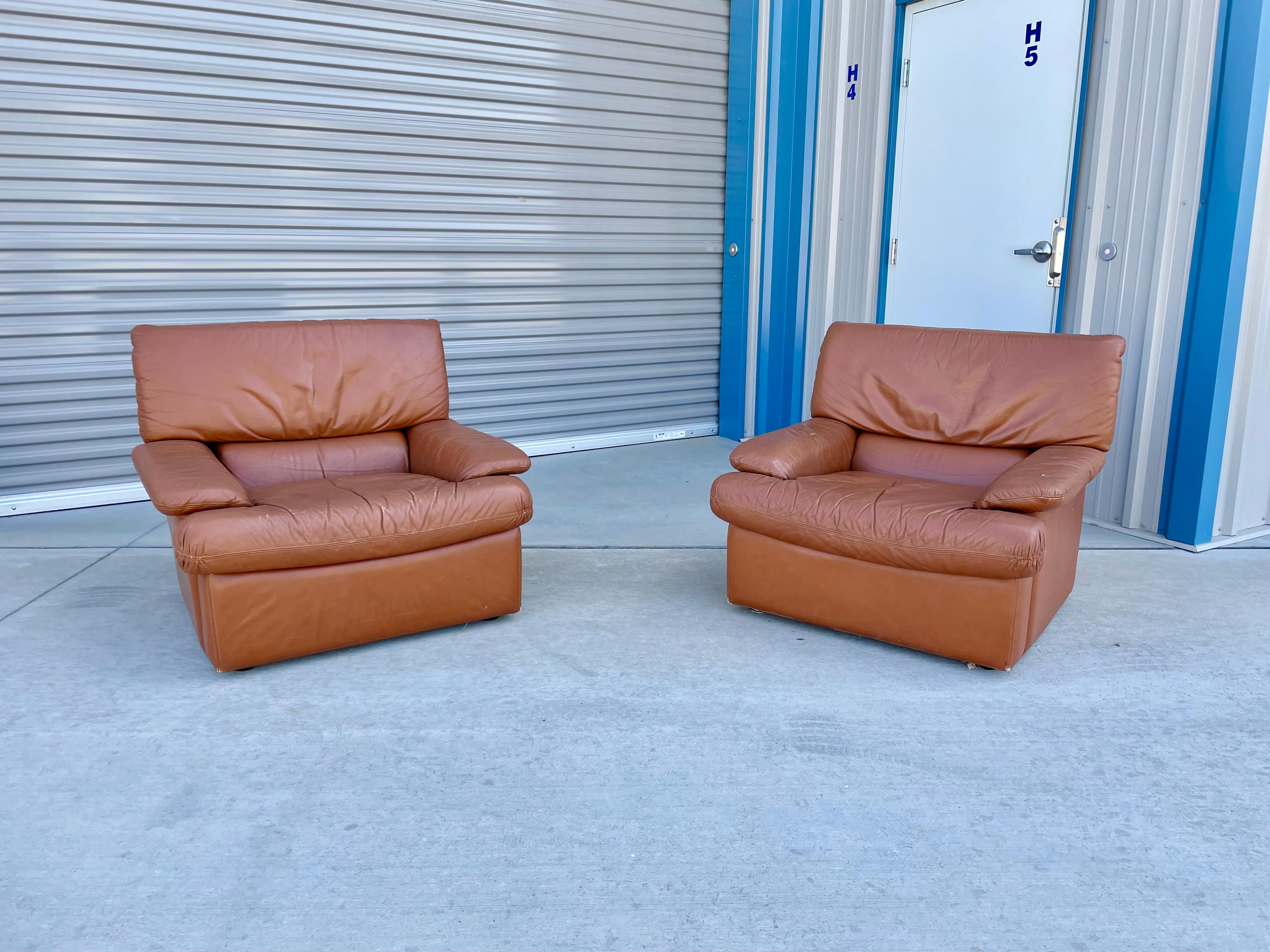 Fauteuils de salon en cuir vintage inspirés de De Sede et fabriqués en Italie dans les années 1970. Ces chaises longues, compte tenu de leur taille, constituent une paire parfaite pour votre espace de vie. Les chaises sont également recouvertes de