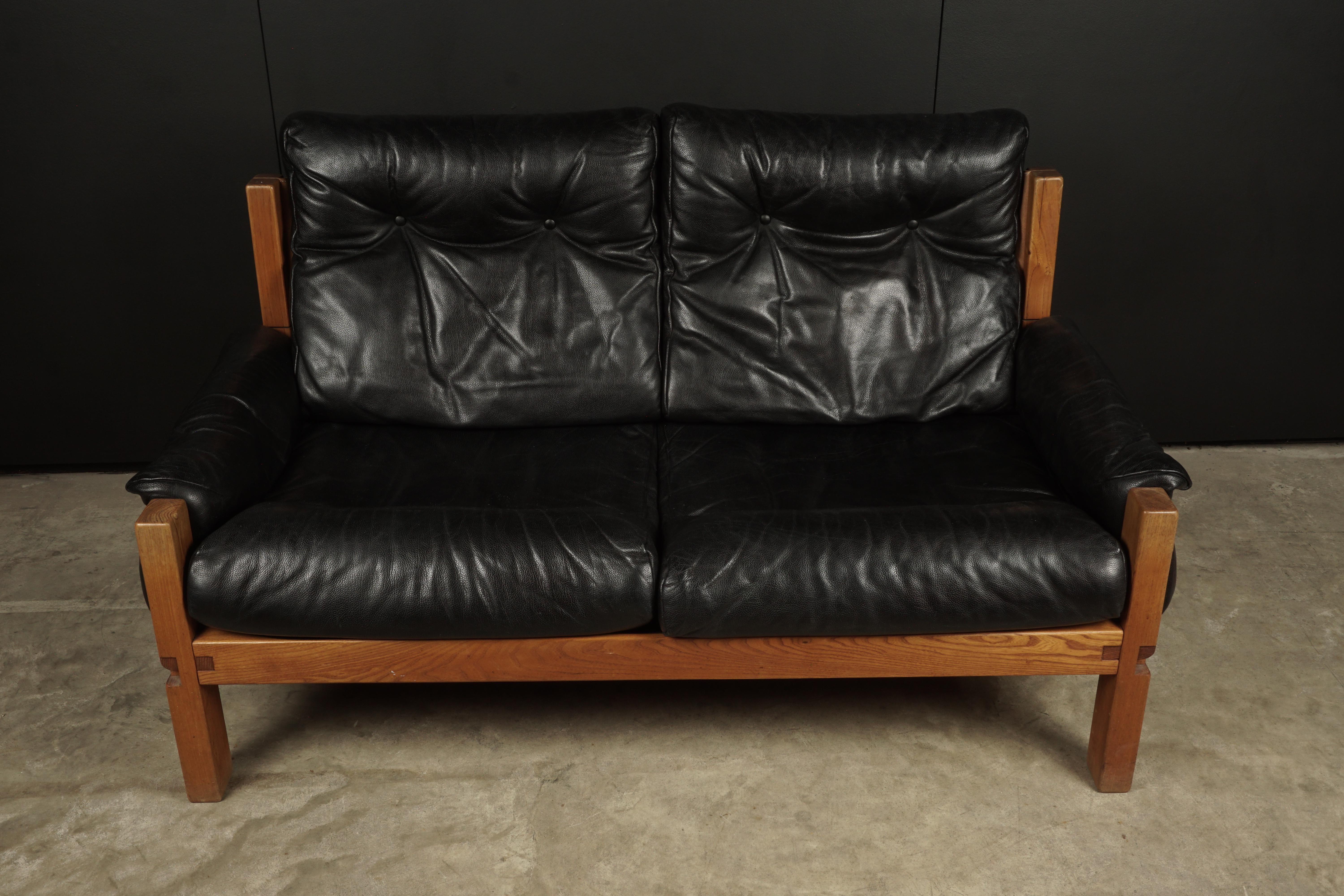 Vintage leather loveseat designed by Pierre Chapo, France 1950s. Solid elm construction with cognac leather straps. Black leather cushions with light patina and wear. Superb quality.