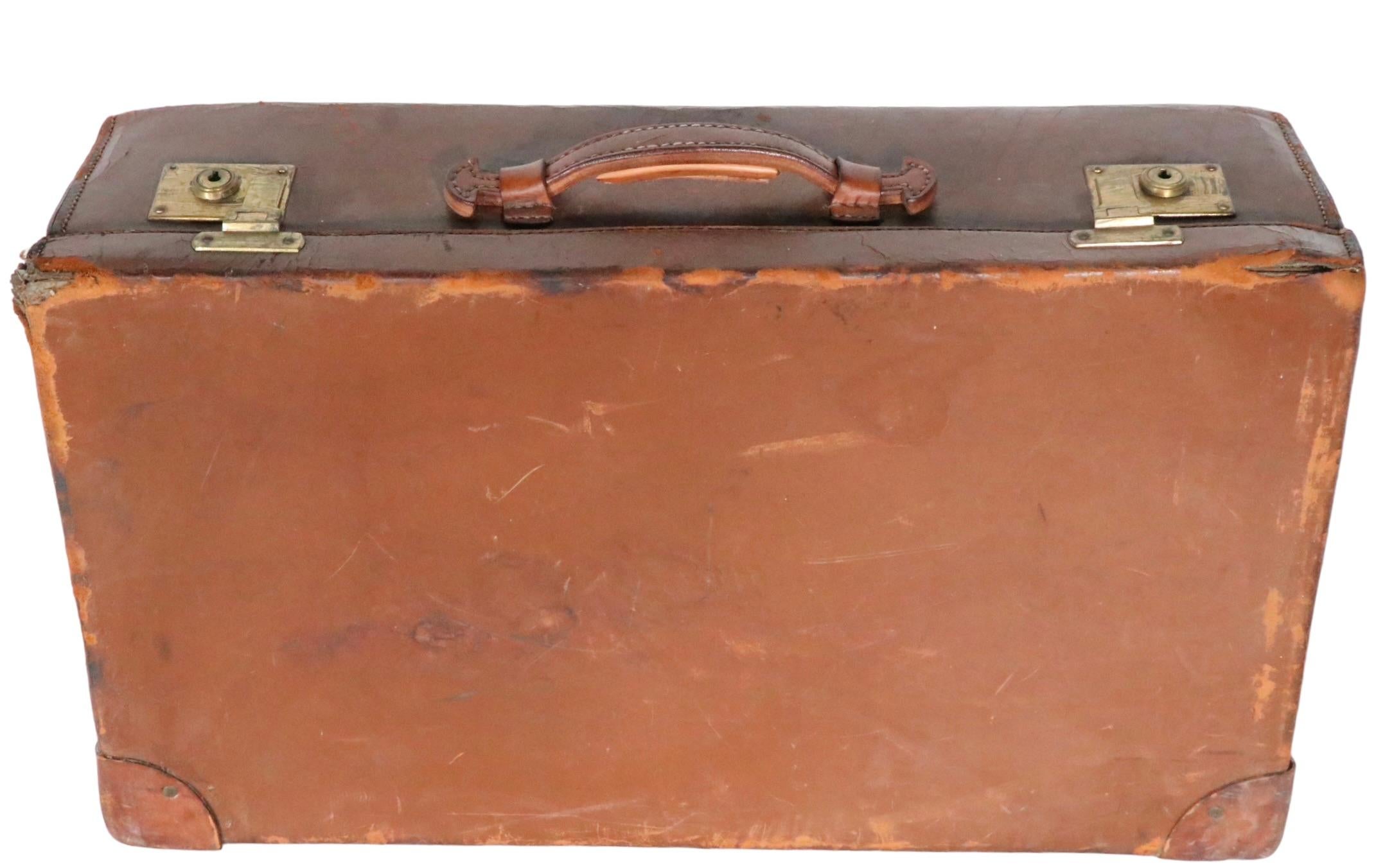 Vintage leather suitcase by noted American maker Crouch & Fitzgerald. The suitcase is in good, estate condition, it shows some signs of age and use, notable significant wear at two corners, please see images. It is marked with the makers table in