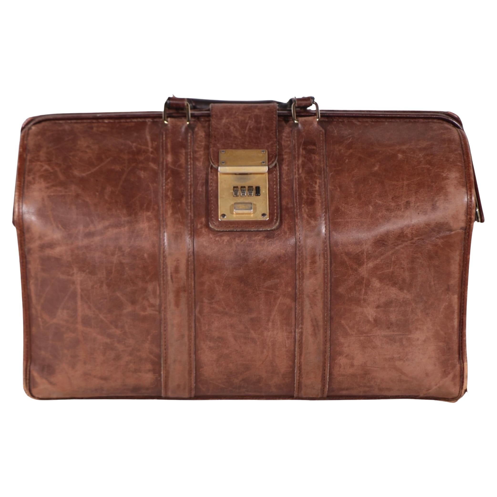 Chic leather valise, handbag, suitcase in good, original condition. The bag has two leather grip handles, and a leather closure strap with locking mechanism. The lock is not locked, we do not have the combination. 
 Overall very good vintage