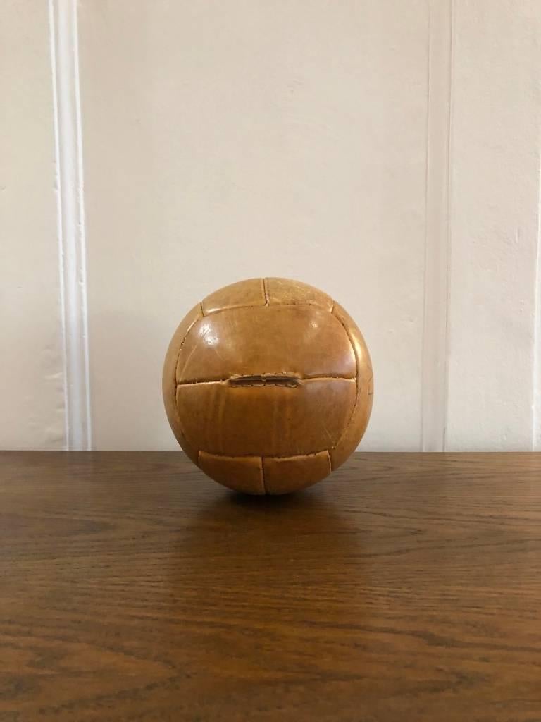 This medicine ball comes from the stock of an old Czech gymnasium. Made in the 1940s. Thick cowhide with patina. Cleaned and treated with a special leather care, writing on surface. Weight: 1kg.