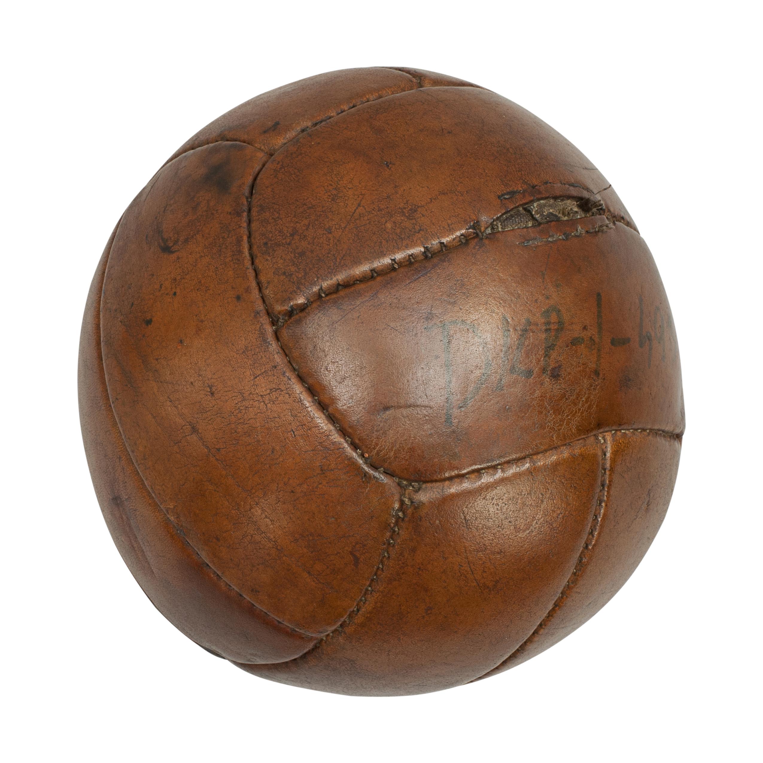 Vintage leather medicine ball.
A good vintage leather medicine ball in the shape of a football. It is made from twelve leather panels and the leather has a nice tan polished finish. Written on one of the panels 'DKP - I - S933'.
This ball is