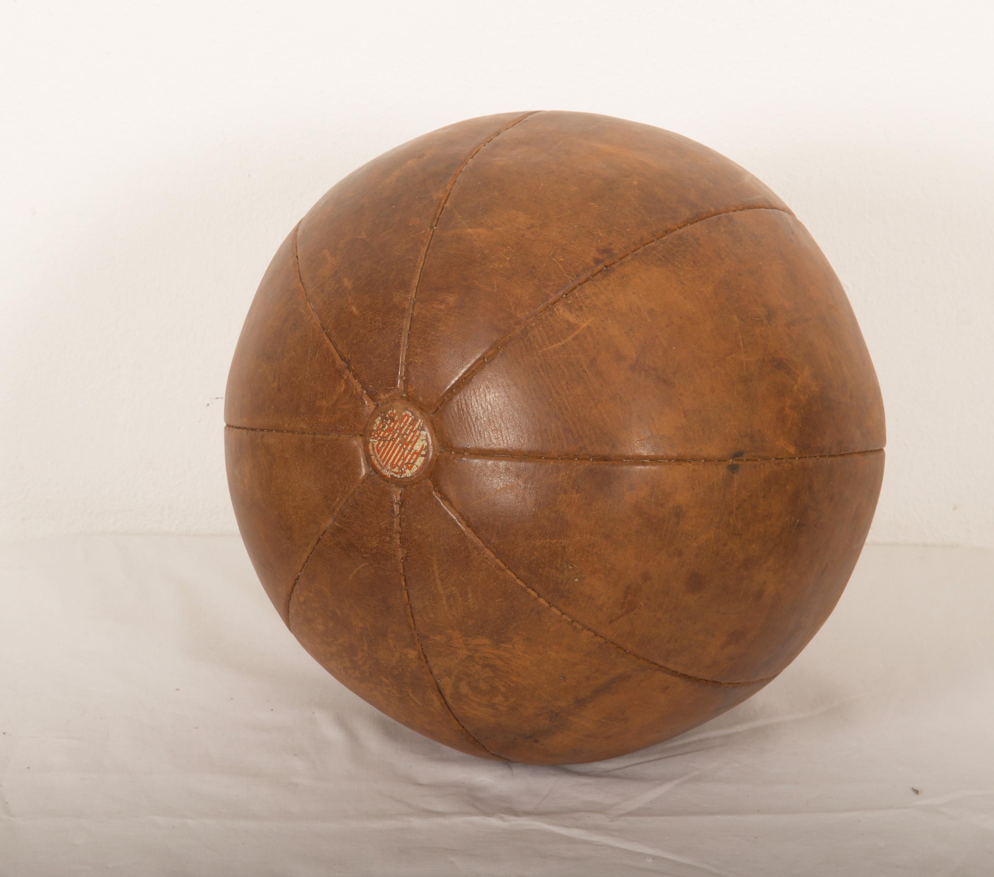 Original patinated leather medicine ball with a branded manufacturers mark 