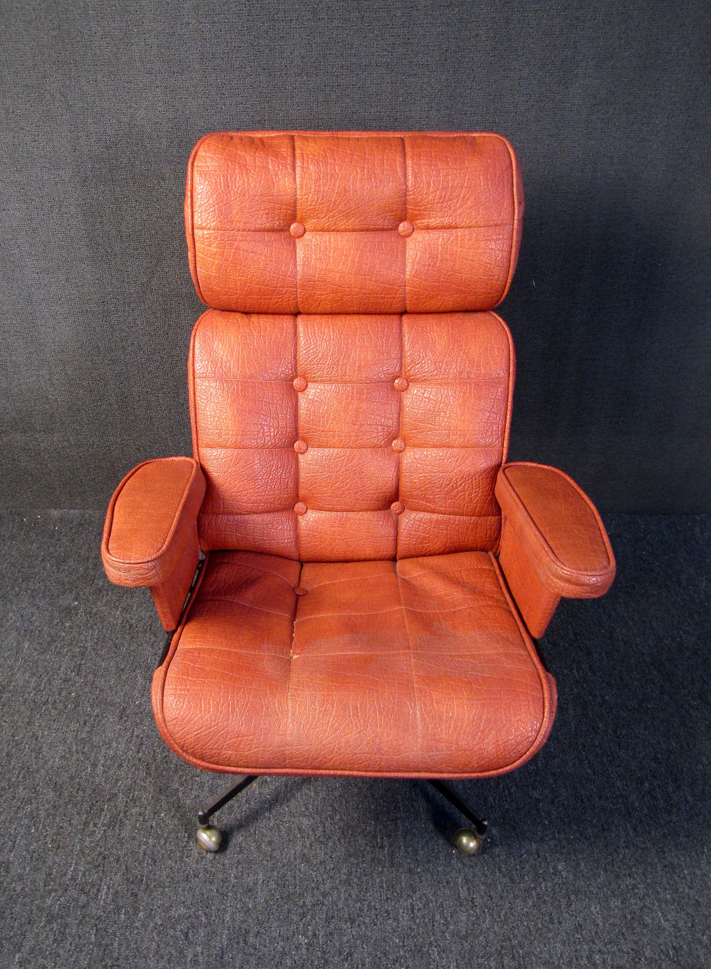A vintage leather office chair that pops in a rich orange color, this Mid-Century Modern chair is beautifully designed, comfortable, and made in the USA. With a rolling base and padded arms, this chair would be a vibrant addition to any home office.