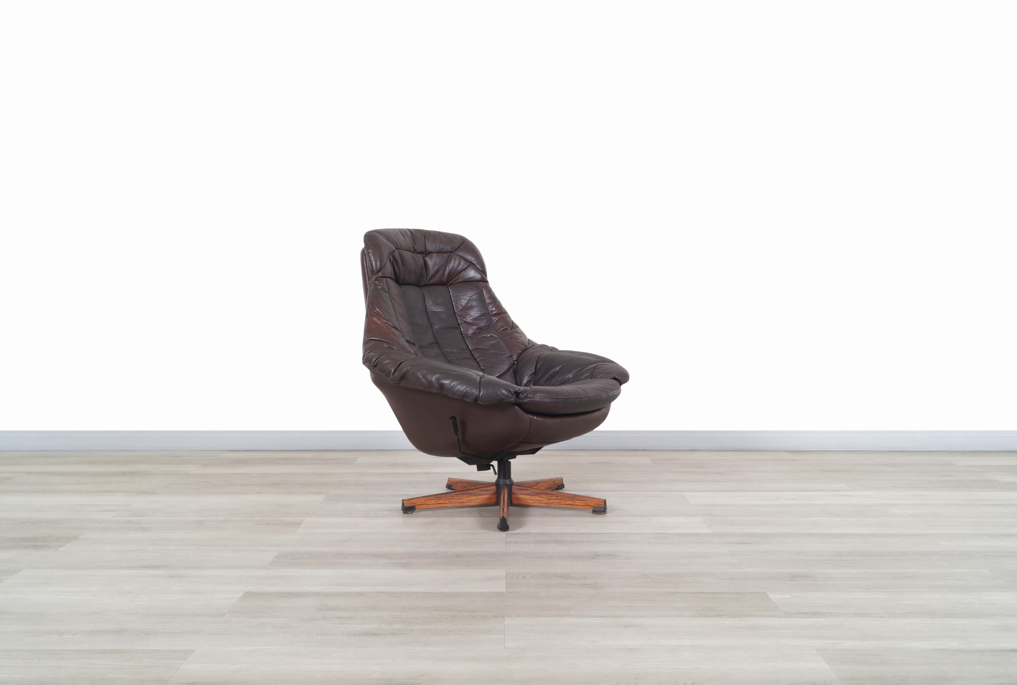 Beautiful vintage leather reclining swivel lounge chair designed by H.W. Klein for Bramin in Denmark, circa 1960s. Feature an ergonomic design that provides better relaxation when sitting. The chair is covered by original dark brown leather that is