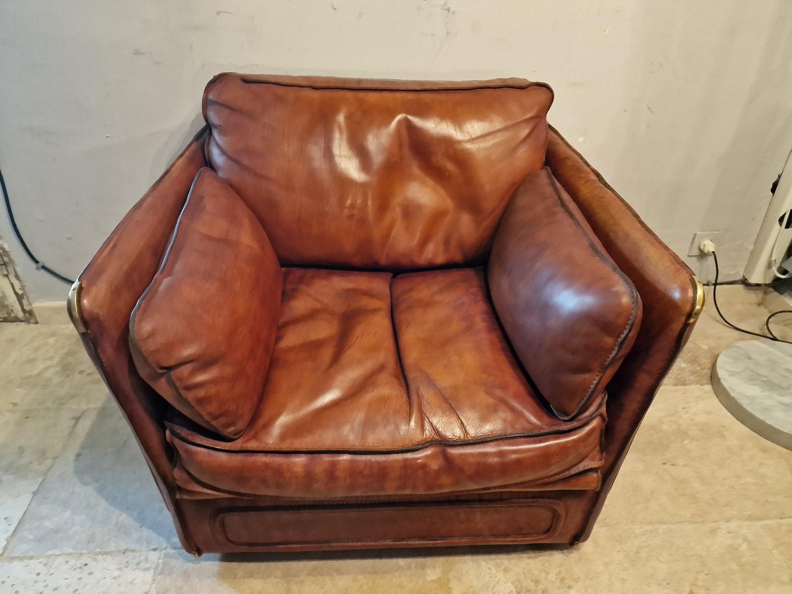 Vintage Roche Bobois armchair in thick buffalo leather and goose feather, brass corners.  Circa 1970, in very good condition.
 3-seater and 2-seater sofas also available.