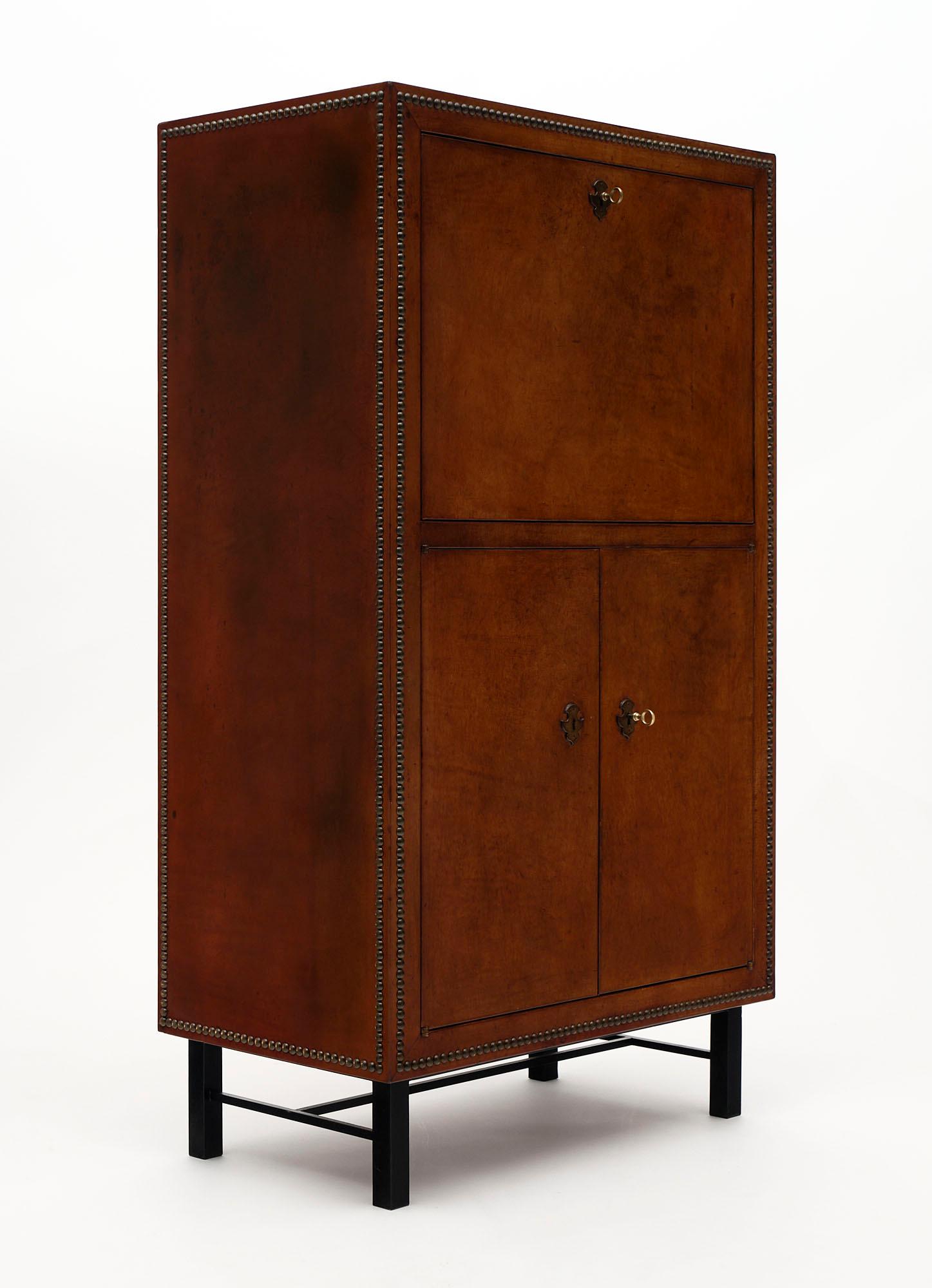 Secrétaire, French, Mid-Century Modern made of cherry wood covered with lambskin leather and decorated with brass nails throughout. The drop front offers a large writing surface with plenty of space inside. Additional storage is featured below the