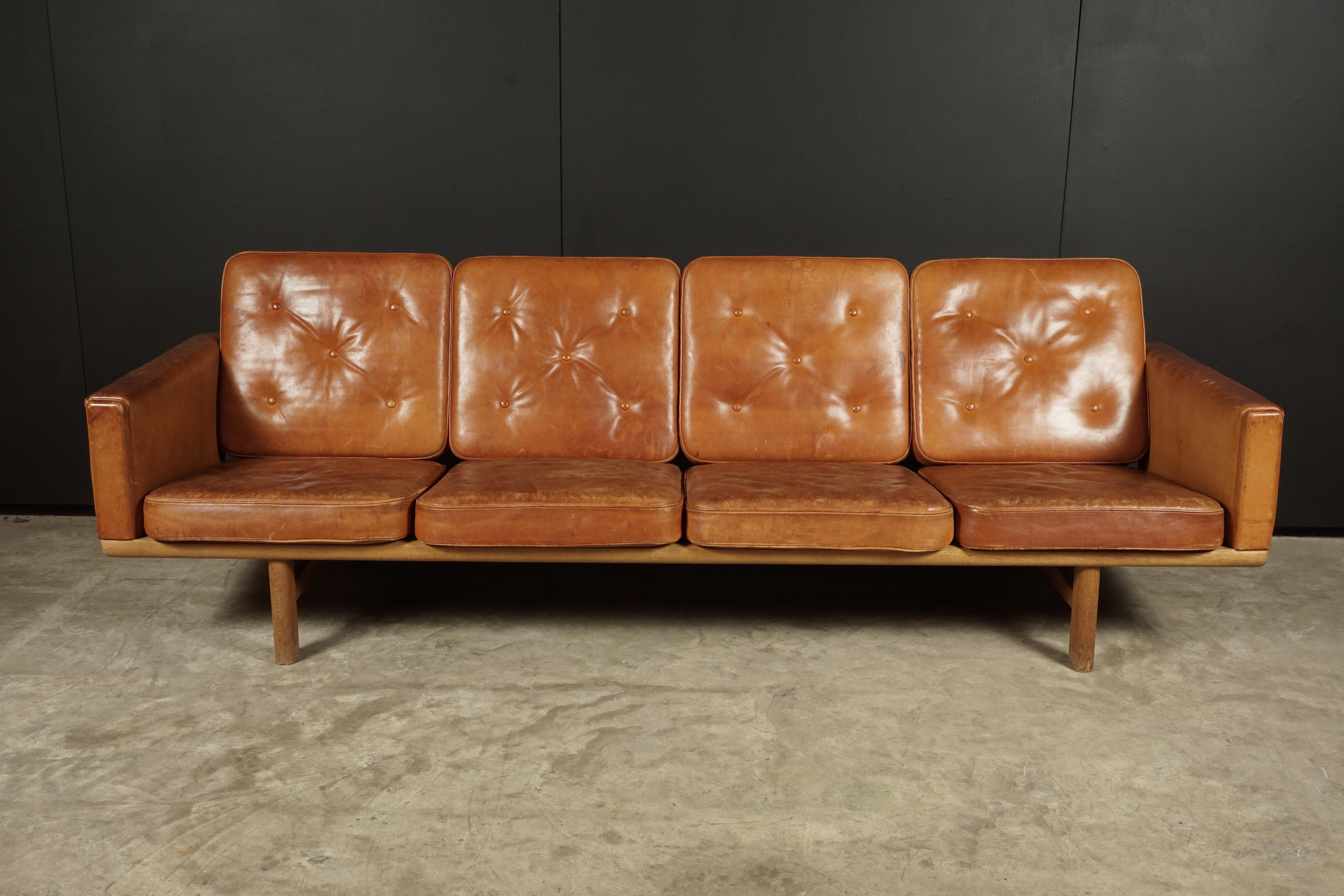 Vintage leather sofa designed by Hans Wegner, Model 236, Denmark 1950s. Original Cognac leather upholstery with amazing patina and wear. Solid oak frame with original cushions Manufactured by GETAMA, Denmark and stamped underneath.