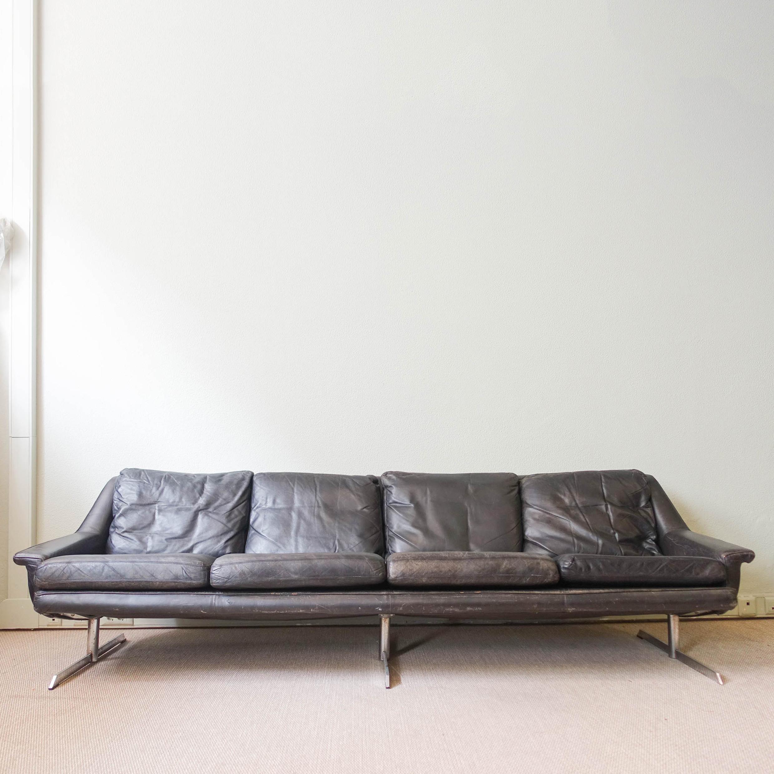 A model 802 designed by Werner Langenfeld and produced by ESA Møbelværk in Denmark, during the 1960's. It is reupholstered in the original black leather, that has some cracks in one of the cushions, and it's a bit discolored. It has three chrome