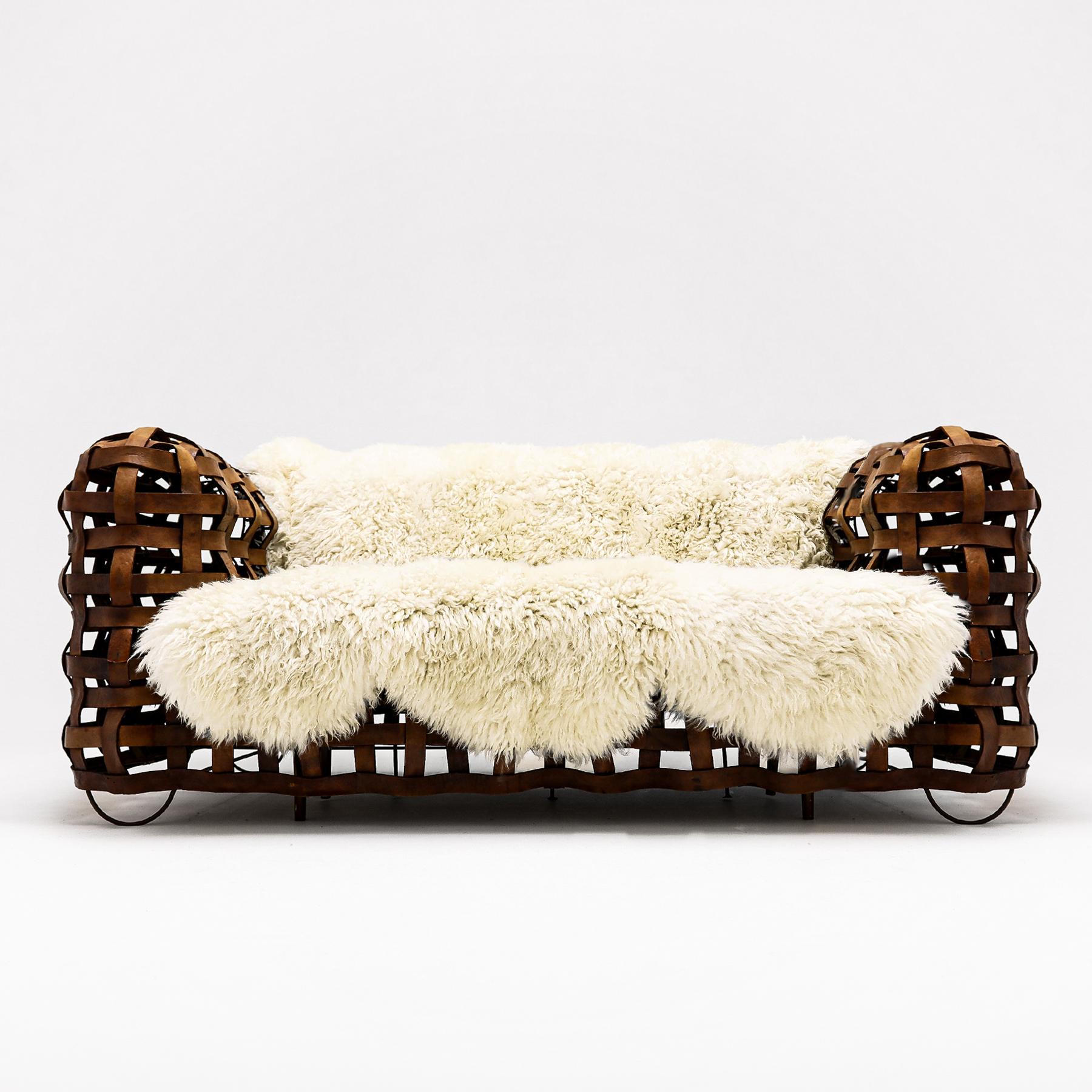 An extraordinary hand crafted Vintage French leather strap sofa with upholstered bench seat and bespoke sheepskin throw.

This is an extremely unusual and beautifully designed hand crafted sofa constructed from leather straps over a welded wire