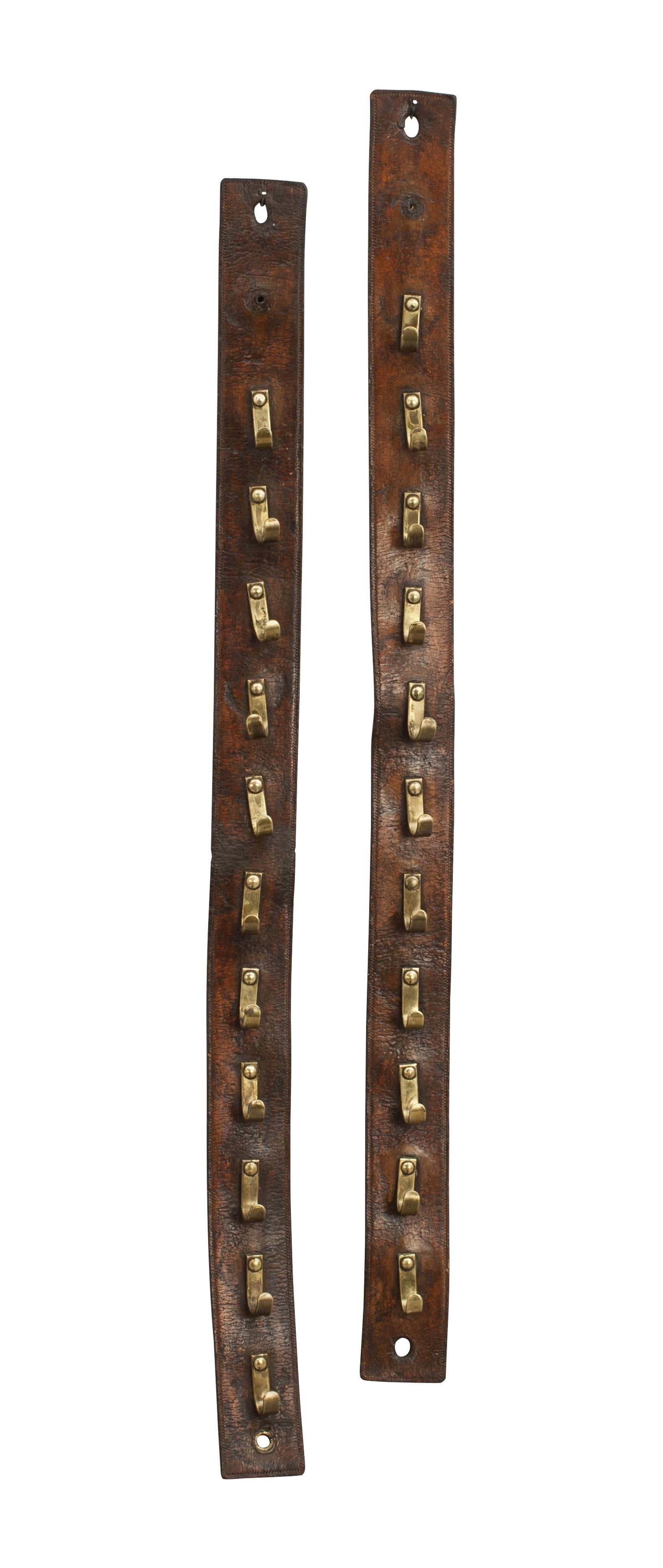 A good quality whip rack made of dark brown leather. There are 11 brass hooks on each strap. They are riveted to the leather strap with a second piece of leather sewn to the back to hide the back of the rivets. There are two hanging holes on each