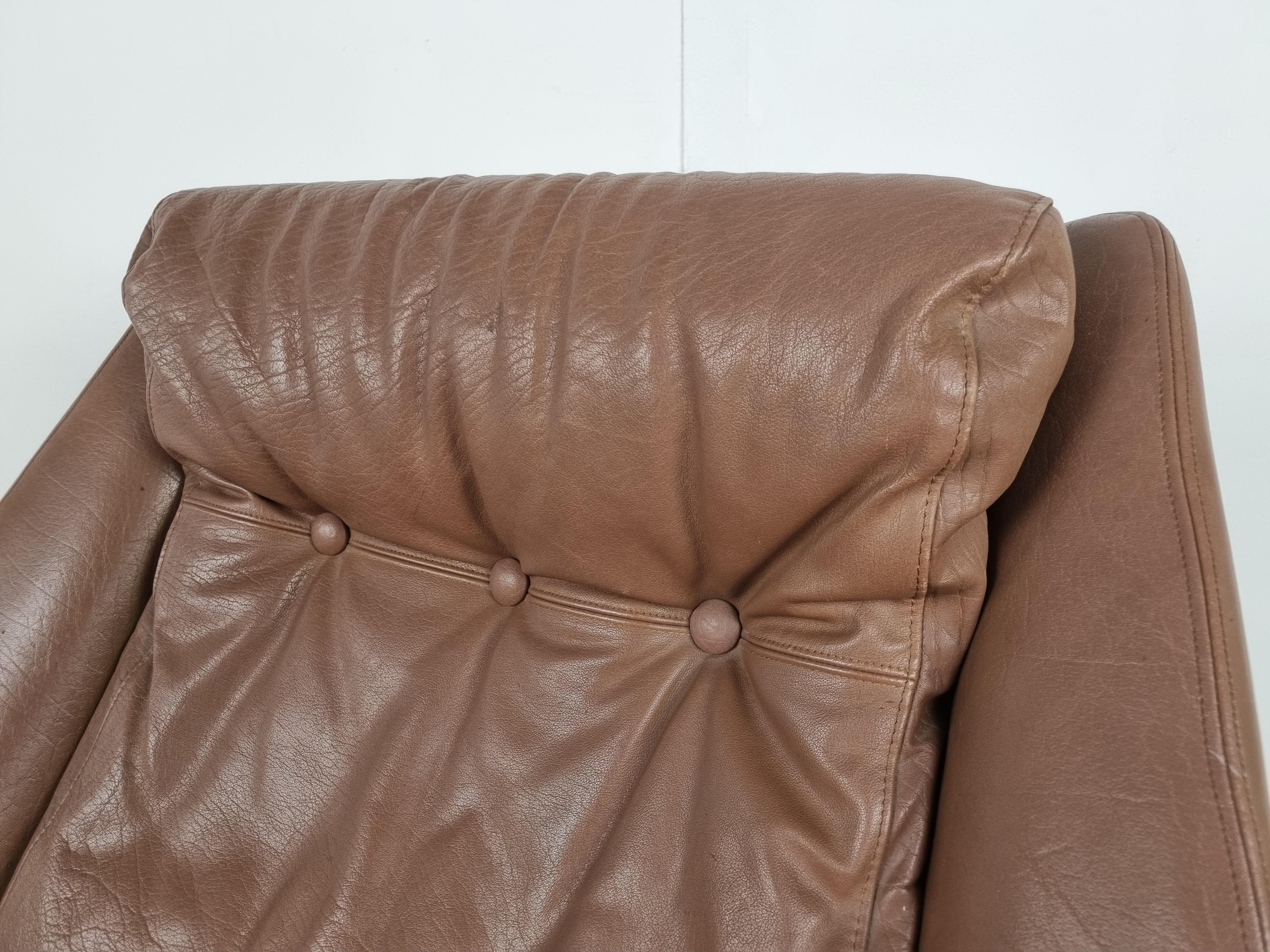 Mid century modern brown leather swivel chair.

Very comfortable swivel armchair with thick leather cushions.

Good seating position.

Very good condition.

Start shaped metal base with wooden look

The chair is very much in the style of