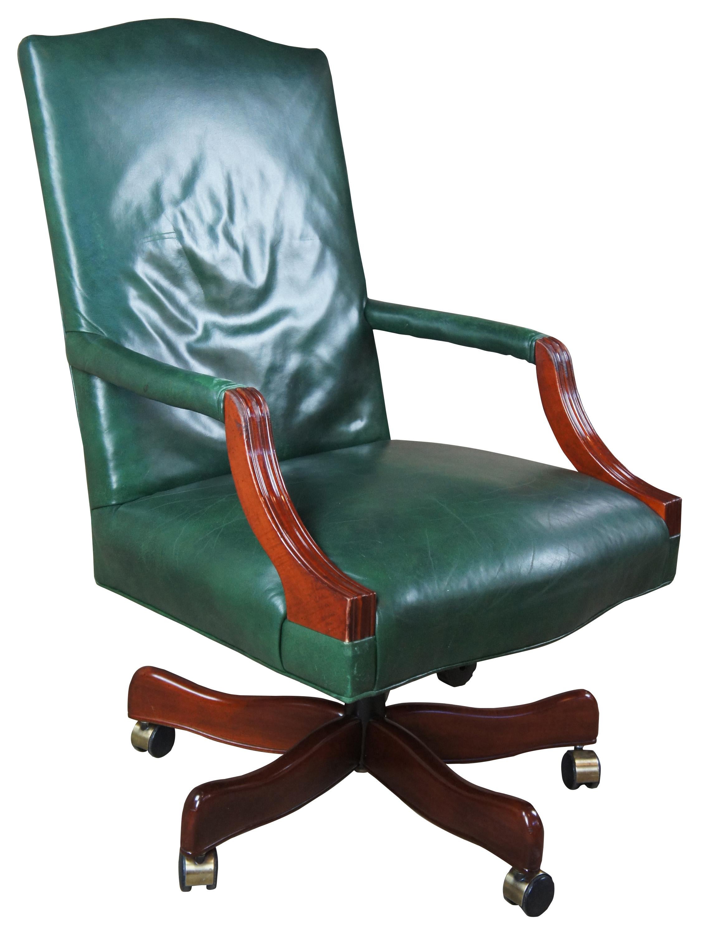 Vintage green leather executive office chair. Traditional with modern flare. Features a cherrywood finish and rolling castors, circa 1990s.