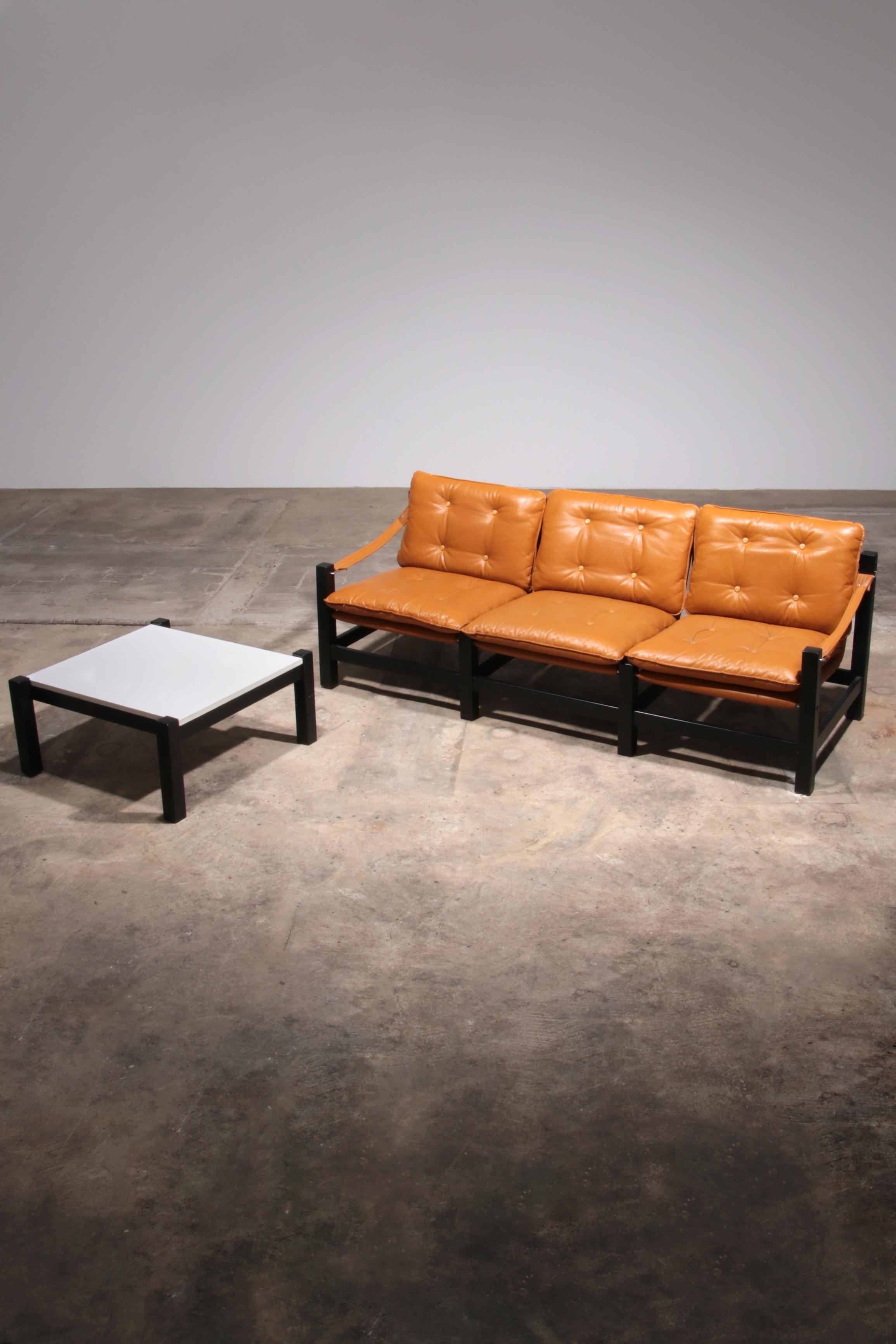 

Transformez votre espace de vie avec ce superbe ensemble canapé trois places et table basse en cuir vintage des années 1970. Doté de magnifiques coussins en cuir jaune maïs et orange, cet ensemble ajoute une touche de couleur et de charme rétro à