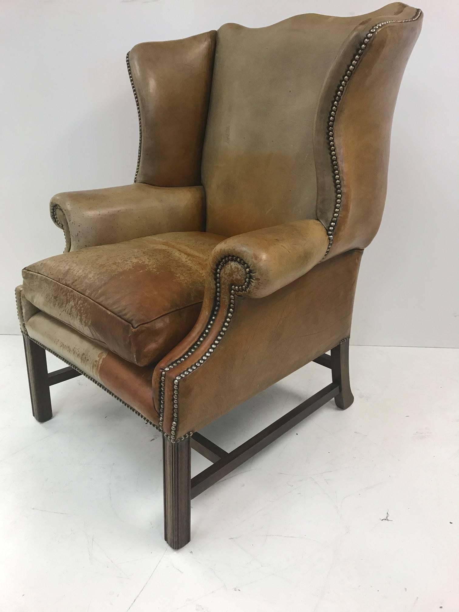 Vintage leather wingback chair with a solid mahogany base and a down filled seat.