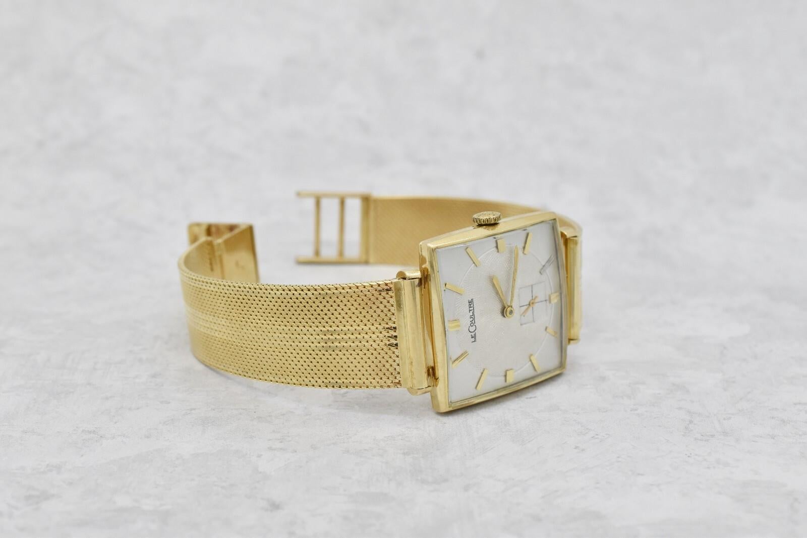 Este reloj vintage LeCoultre Ref. 635-691 destila una elegancia atemporal de mediados de siglo. Alojada en una sólida caja cuadrada de 28 x 28 mm de oro amarillo de 14 quilates, presenta una esfera cepillada en tono plateado con índices minimalistas