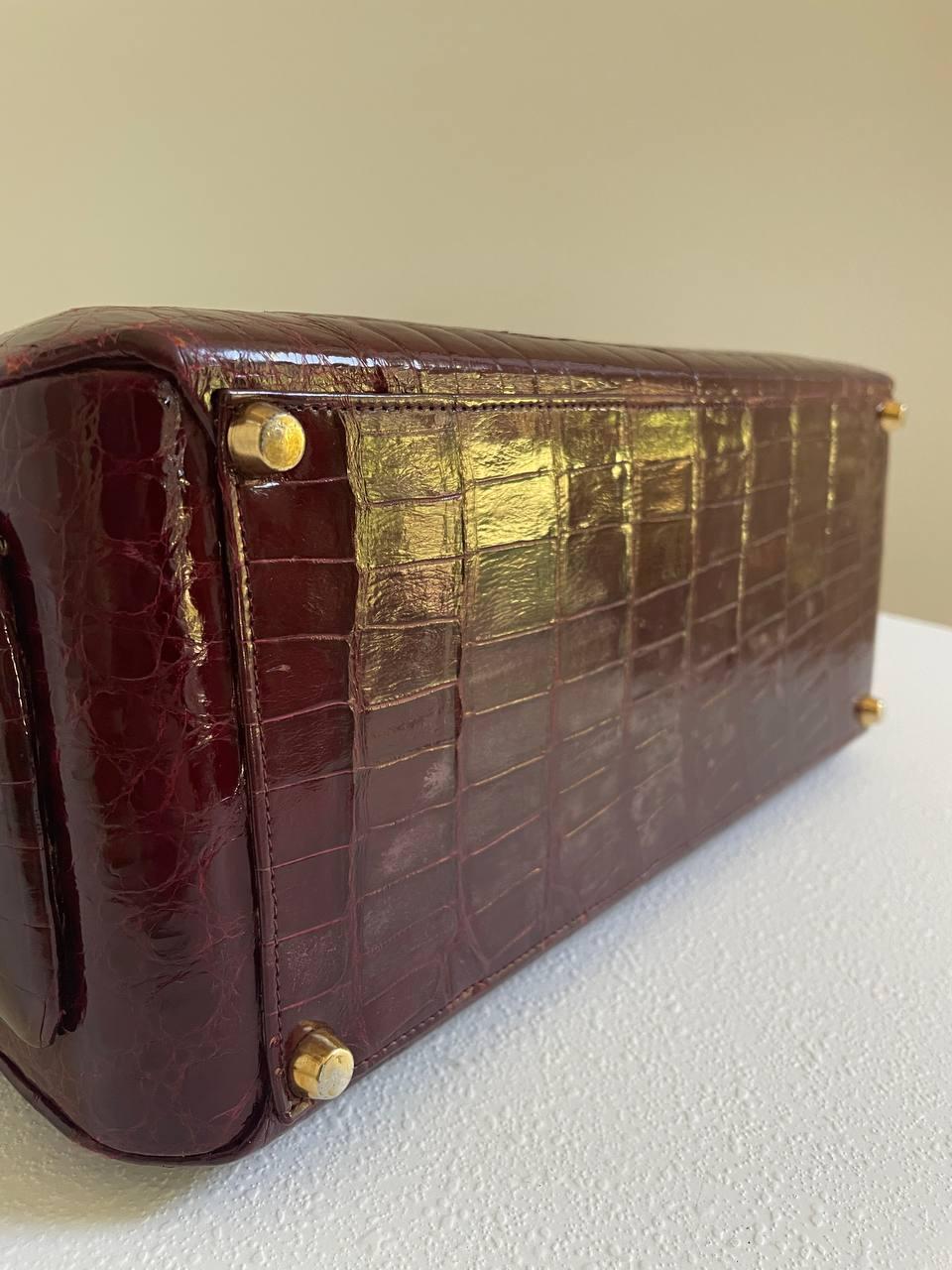 Vintage Lederer vanity case in burgundy crocodile leather. 
Gold-tone hardware.
Leather lining. 
Buckle closure. 
Measurements: 
height: 10