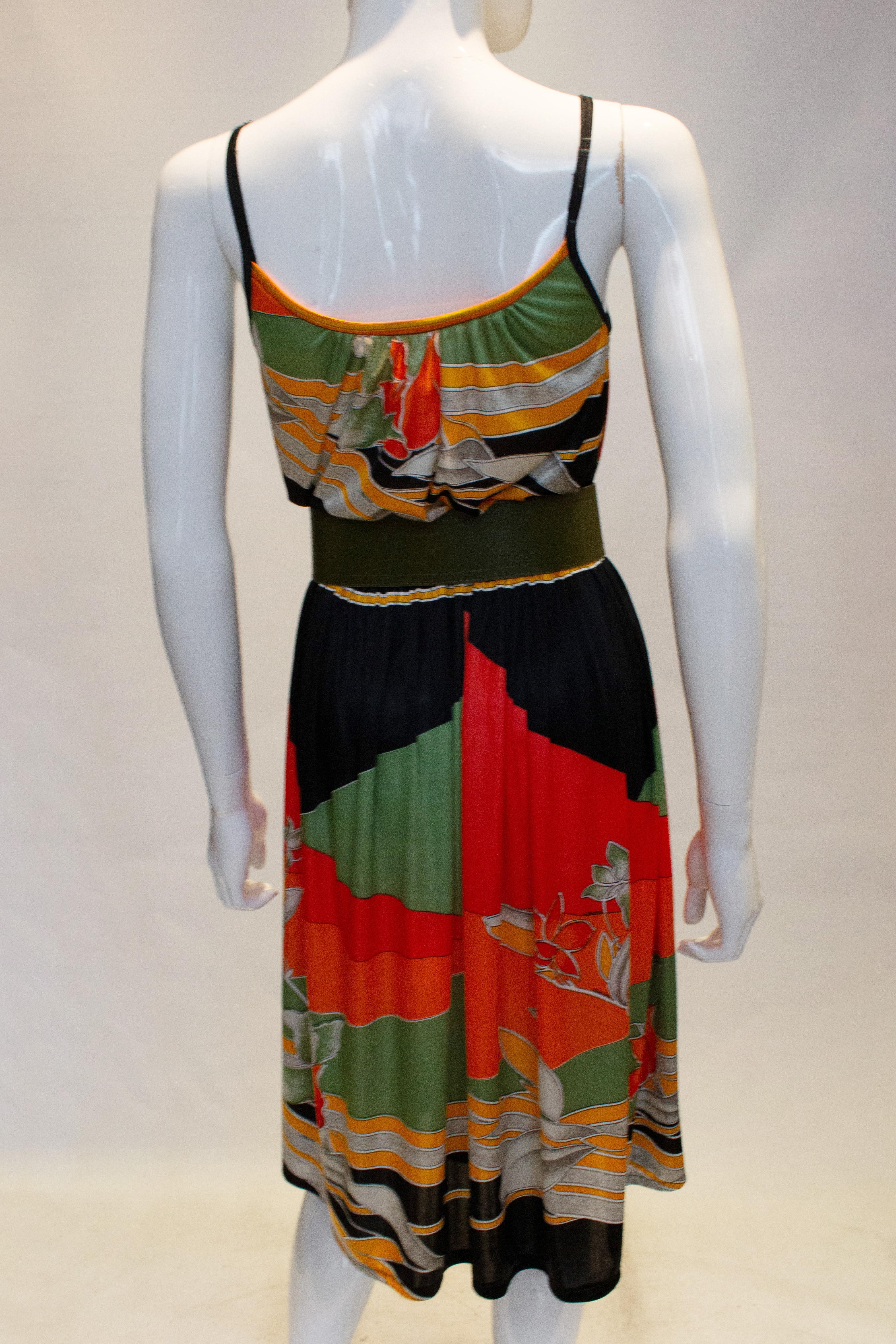 A great vintage dress by Leonard, Paris.  The jersey dress is in a great mix  of colours, pumpkin and green. It has an elastic waist and spagetti straps.
Measurements: Bust 34'', waist 27 - 32'', length 47''
